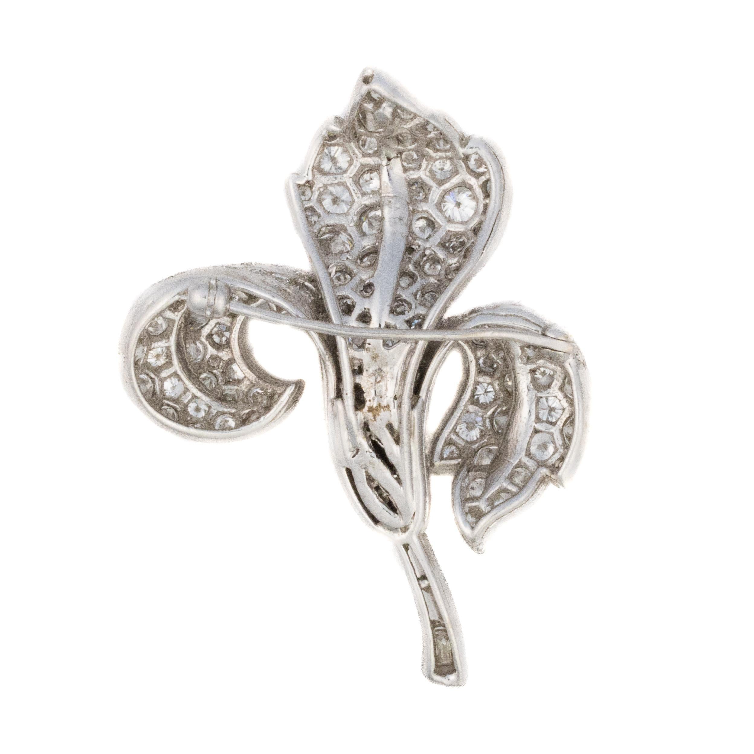 Diamond Floral Brooch in Platinum

This Brooch takes the form of a stylized flower, gracefully rendered in platinum and adorned with a dazzling array of round brilliant, baguette, and marquise-cut diamonds. The central marquise diamond is set