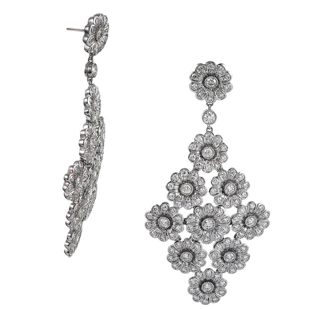 Platinum chandelier earrings, designed in a classic diamond shape made of diamond-studded daisies suspended from a solitary station. The earrings measure 2 ¼ inches long and 1 1/8 inch wide at their widest point. They are set with 400 brilliant