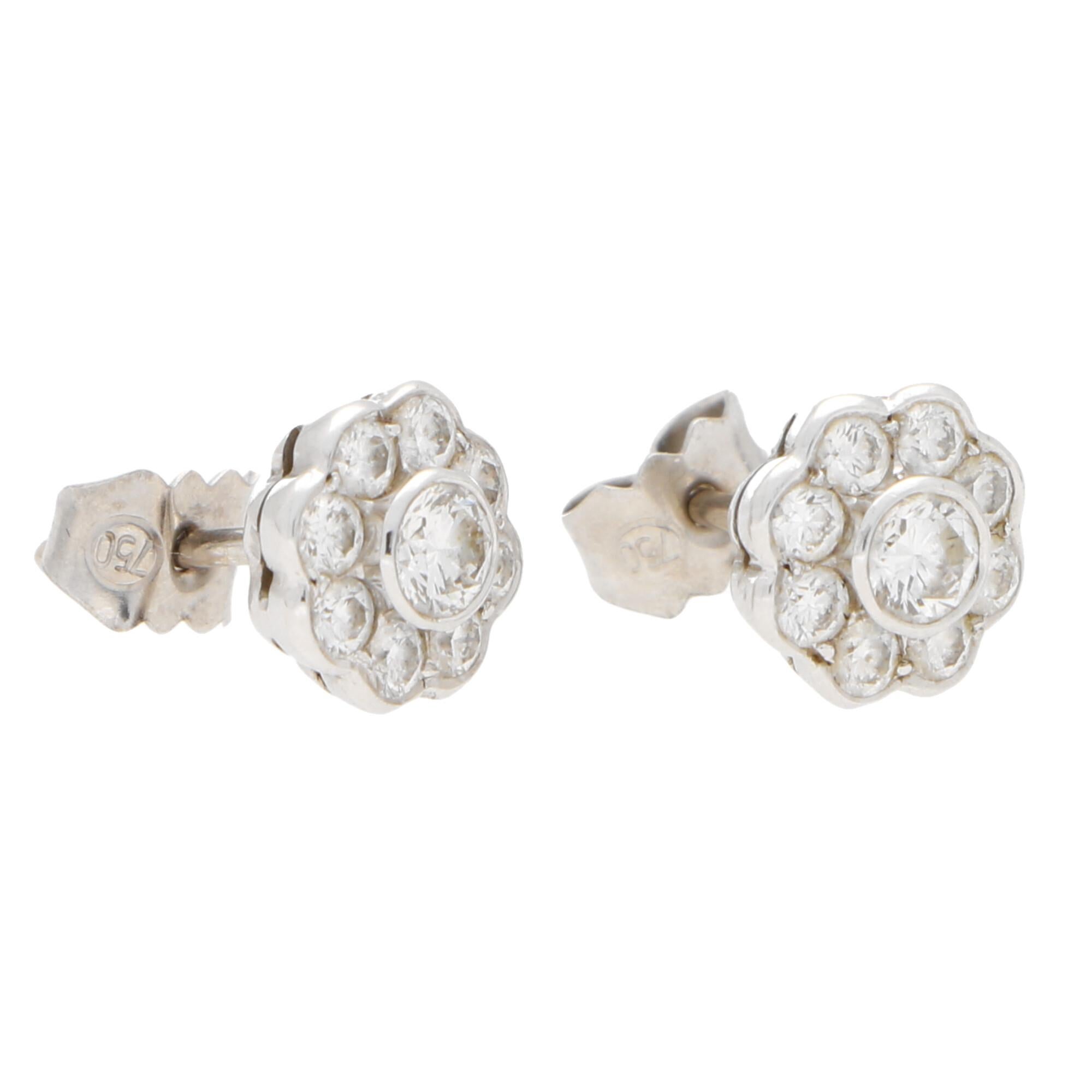 A lovely pair of diamond floral cluster earrings set in 18k white gold.

Each earring centrally features a sparkly round brilliant cut diamond surrounded by a cluster halo of 8 round brilliant-cut diamonds. All of the stones are securely rub over