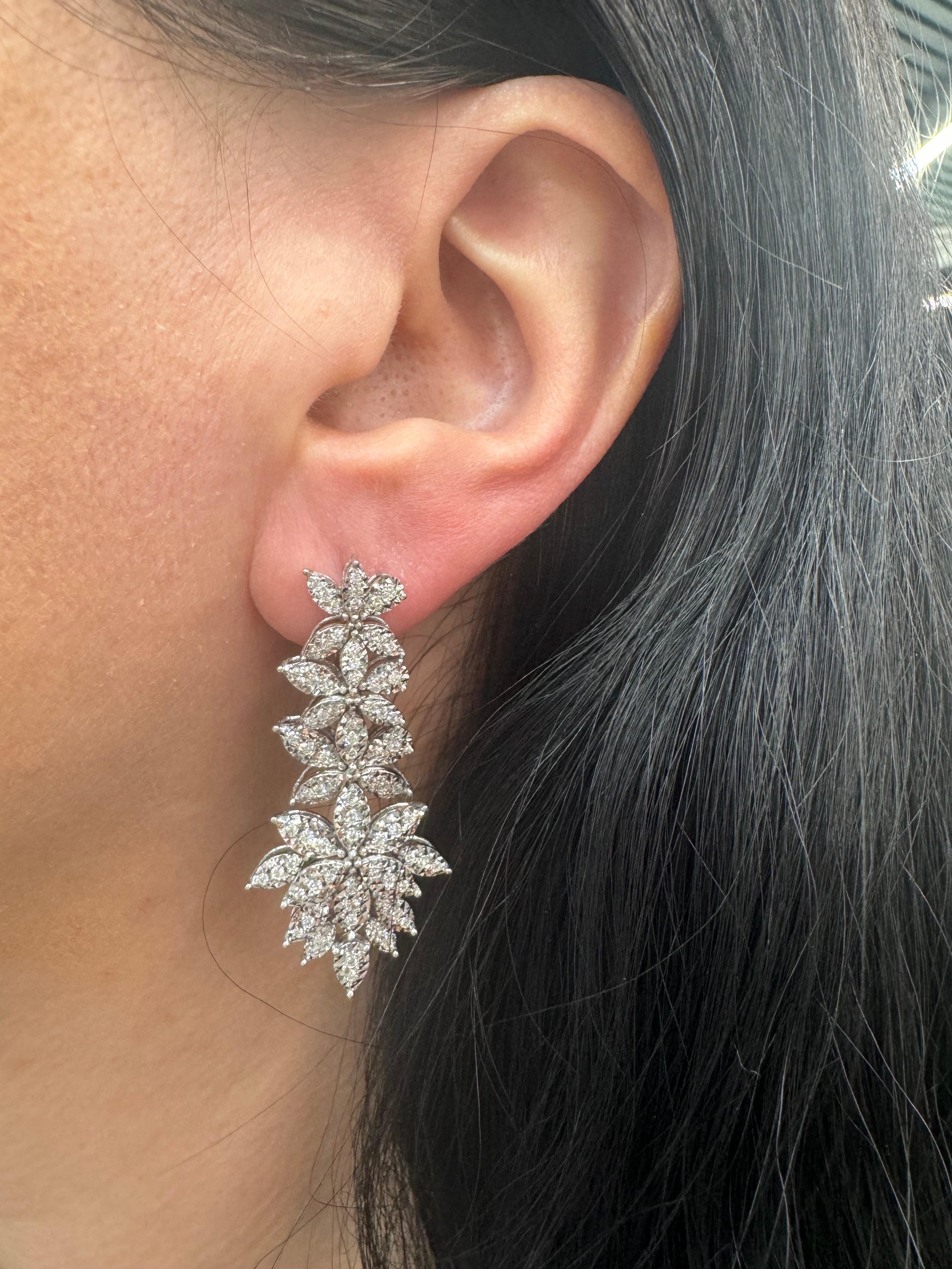 Floral cluster drop earrings featuring 166 round brilliants weighing 0.86 carats in 14 karat white gold.
Color F-G
Clarity VS1-VS2

Big look!! 