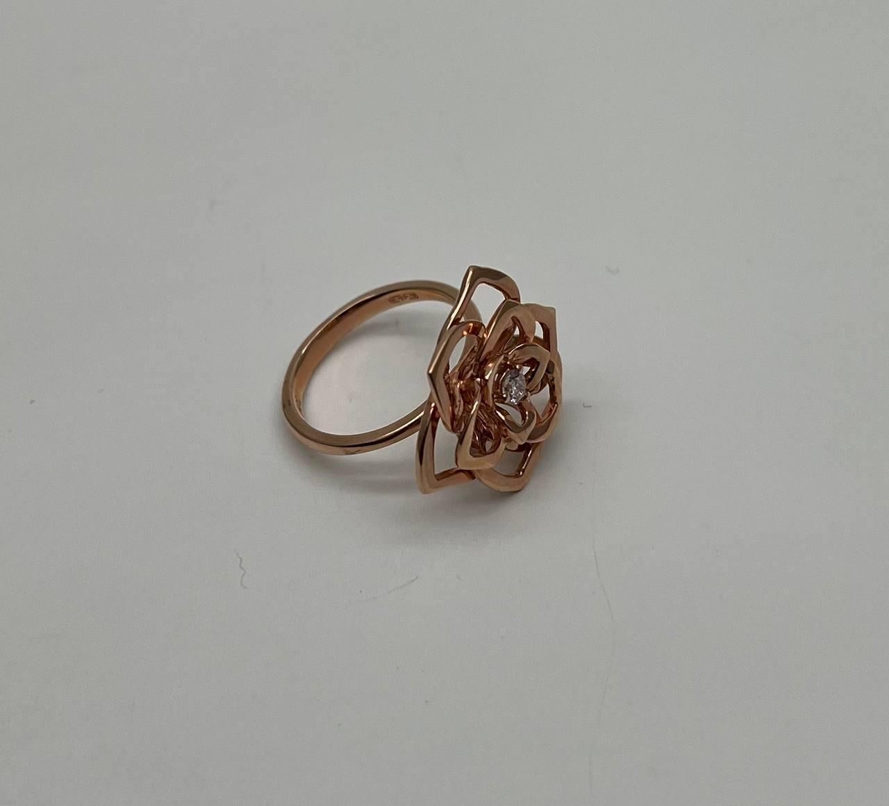 Elegant Rose Gold Floral Diamond Ring. This exquisite ring features an intricate openwork floral motif, with a sparkling diamond at the center. The rose gold setting enhances the delicate and modern aesthetic. 14K Rose Gold. 0.10 CTW Diamonds