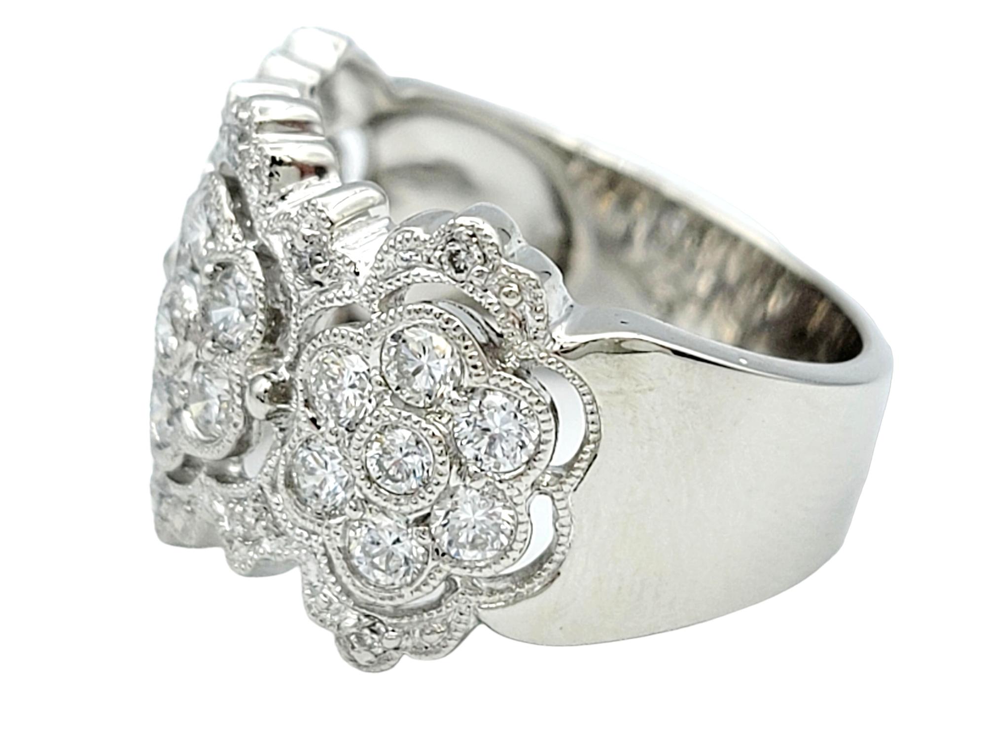 Ring Size: 7.25

This shimmering wide band ring, crafted in polished platinum, is a mesmerizing fusion of sophistication and intricate detailing. The band showcases a captivating floral design that seamlessly combines the brilliance of diamonds with
