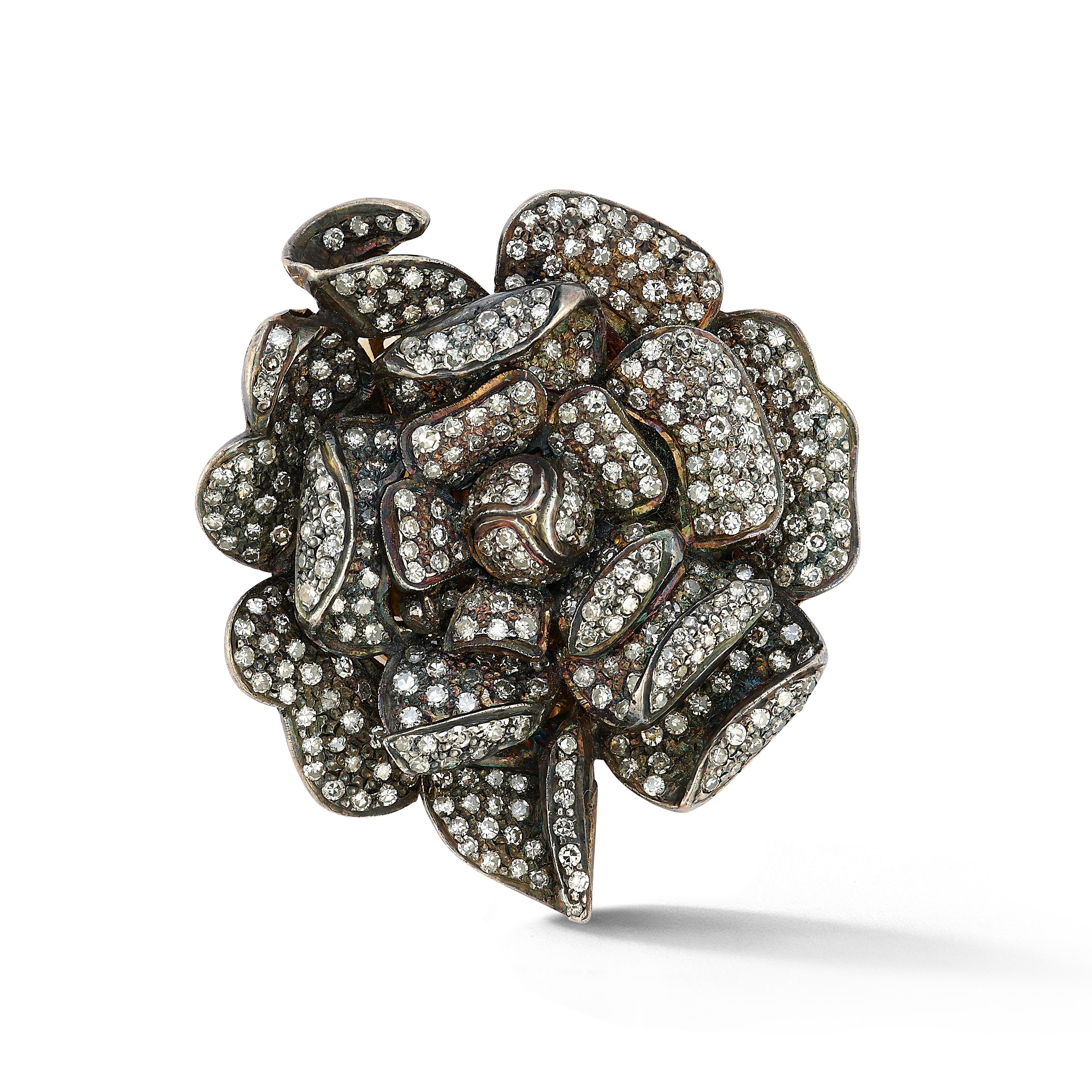 Broche fleur en diamant, 

Broche à motif de fleur présentant environ 4,67 carats de diamants ronds en pavé, sertis en or jaune 18 carats et en argent.

Diamètre : 1.5