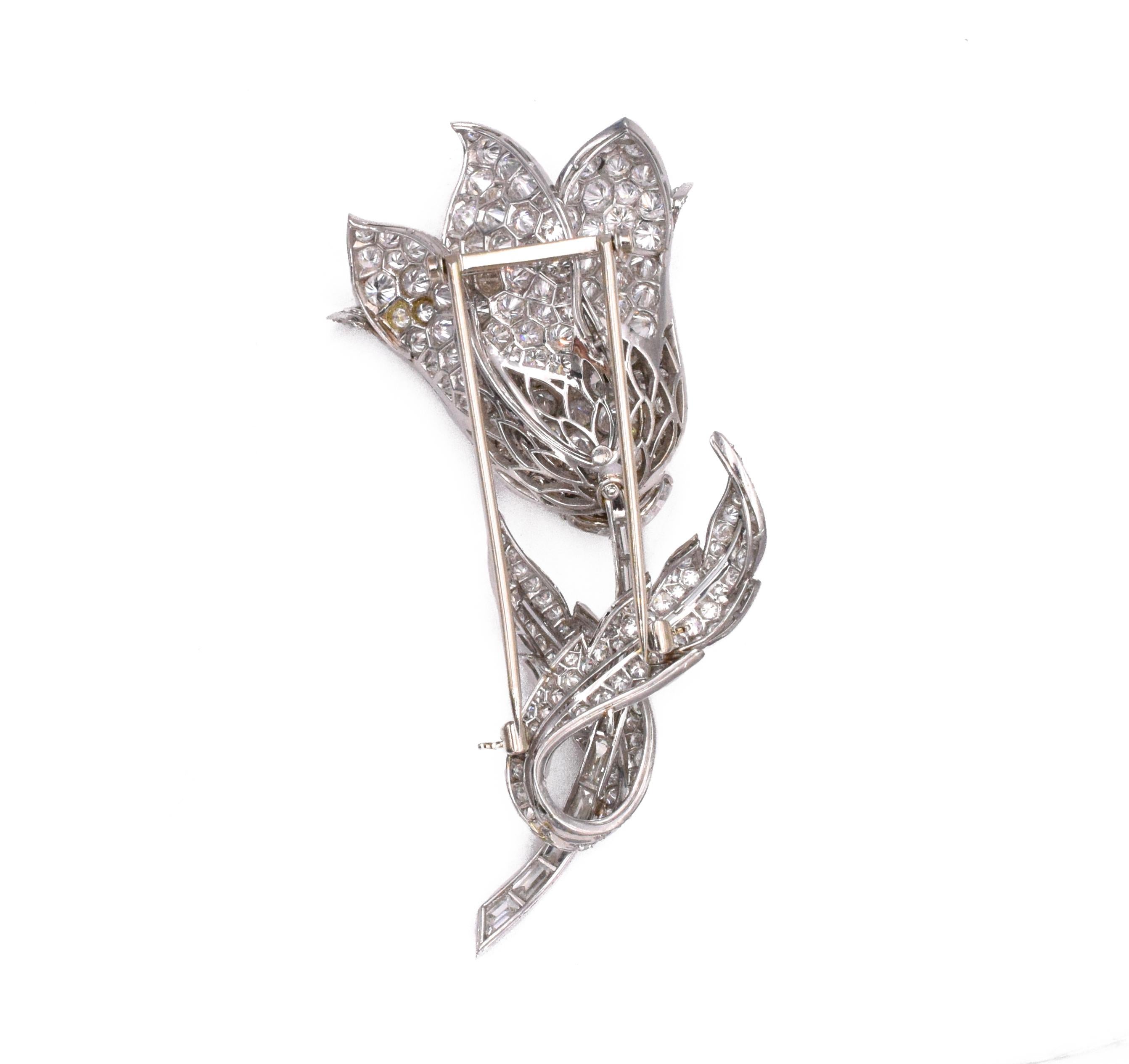 Platinum and Diamond Flower Clip- Brooch The stylized tulip with overlapping petals and leaves pavé-set with round diamonds, completed by a stem of baguette and fancy-shaped diamonds, altogether approximately 17.15 cts.,  
Measuring 3 x 1 3/8 inches.