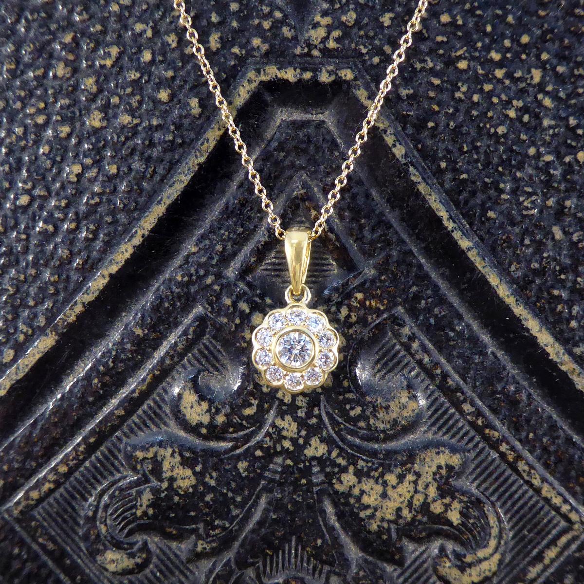 A beautifully sparkly Diamond cluster necklace. Featuring in the centre of this pendant is a 0.12ct Diamond in a bezel setting with a surround of ten slightly smaller Diamonds giving it a floral style with a total of 0.30ct. This piece is fully set