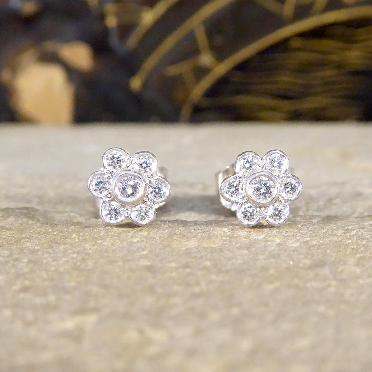 These Diamond flower cluster stud earrings in 18ct White Gold are a dazzling embodiment of elegance and sophistication. Crafted with precision, each earring features a stunning cluster of 6 brilliant-cut diamonds around one centre brilliant cut