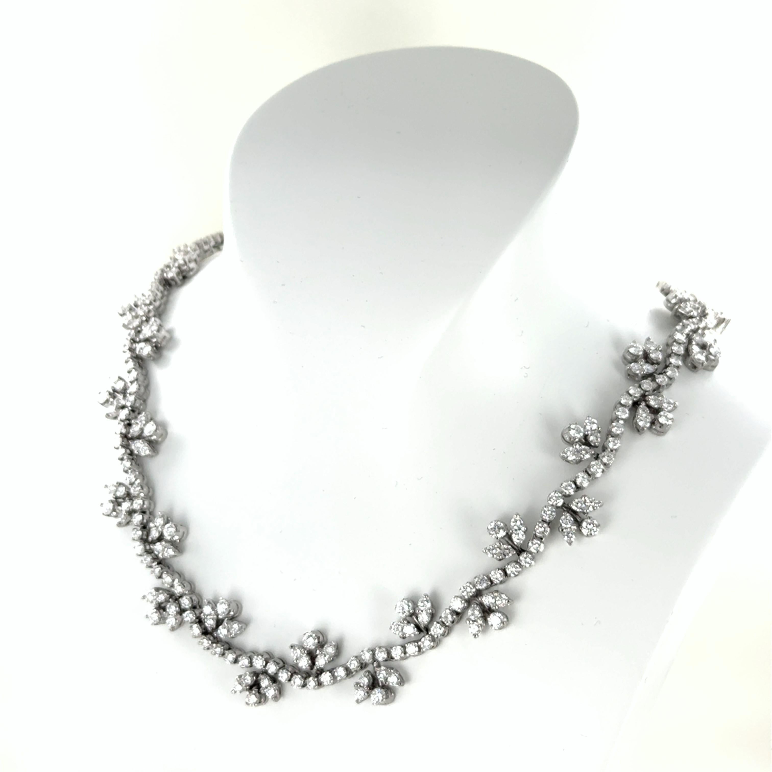 Crafted in 18 karat white gold, this exquisite collier showcases 300 brilliant-cut diamonds totaling 22.50 carats. The diamonds, graded G-H in color and si in clarity, are intricately arranged in a delicate floral motif that gracefully wraps around
