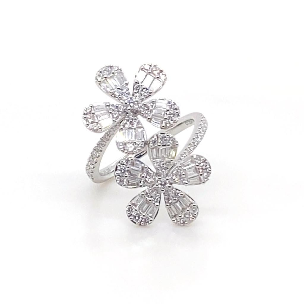 Ad iamond flower cross over ring in 18 karat white gold.

The ring is designed as two flowers in a cross-over formation. 
The flowers are set with baguette and round brilliant cut diamond petals leading to half diamond set tapered fine shoulders,