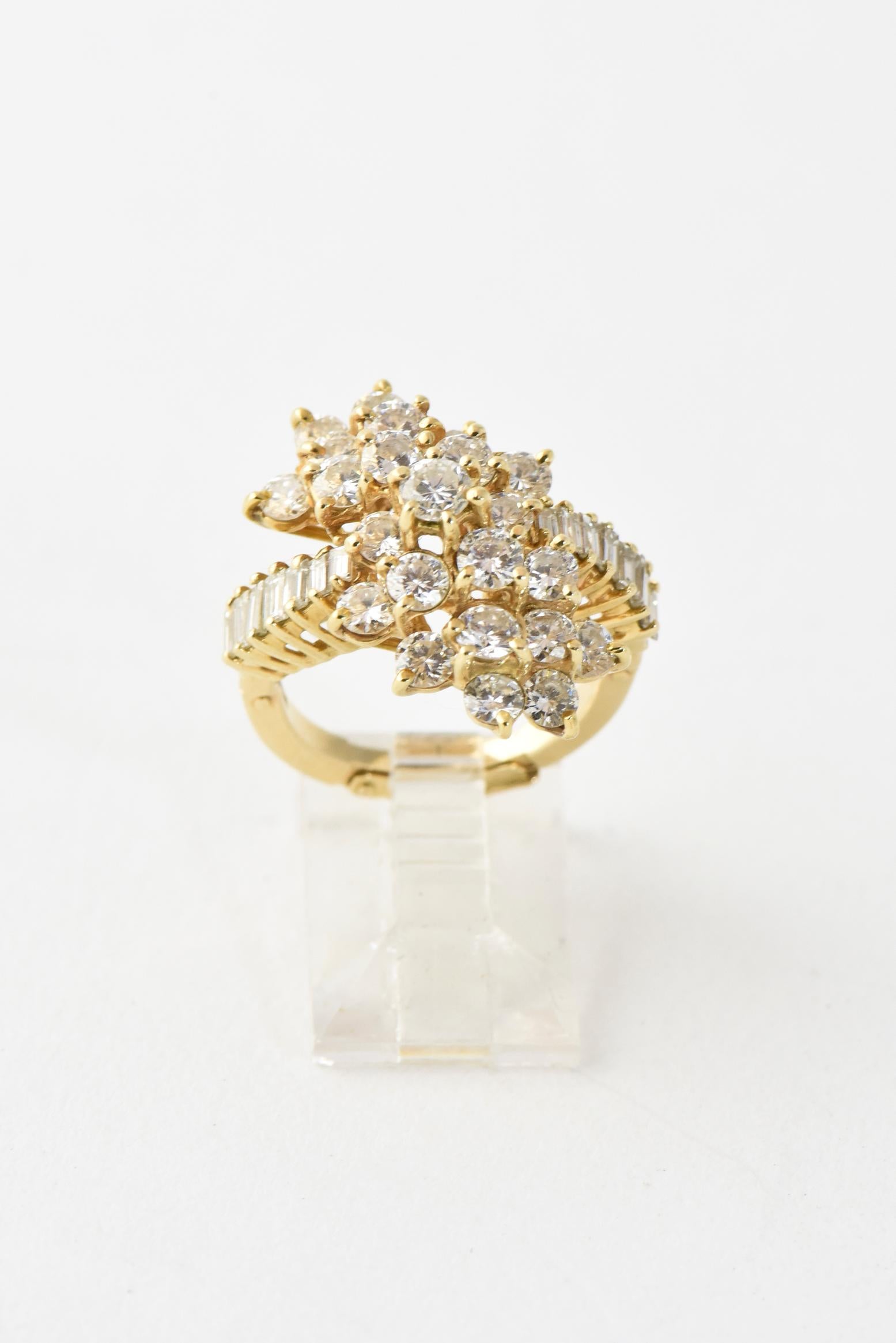Gorgeous floral diamond crossover ring featuring cascading round diamonds that resemble flowers on a diamonds baguette band.  The ring is 18k yellow gold and contains a little bit more than 2 carats of beautiful clean diamonds.  The height top to