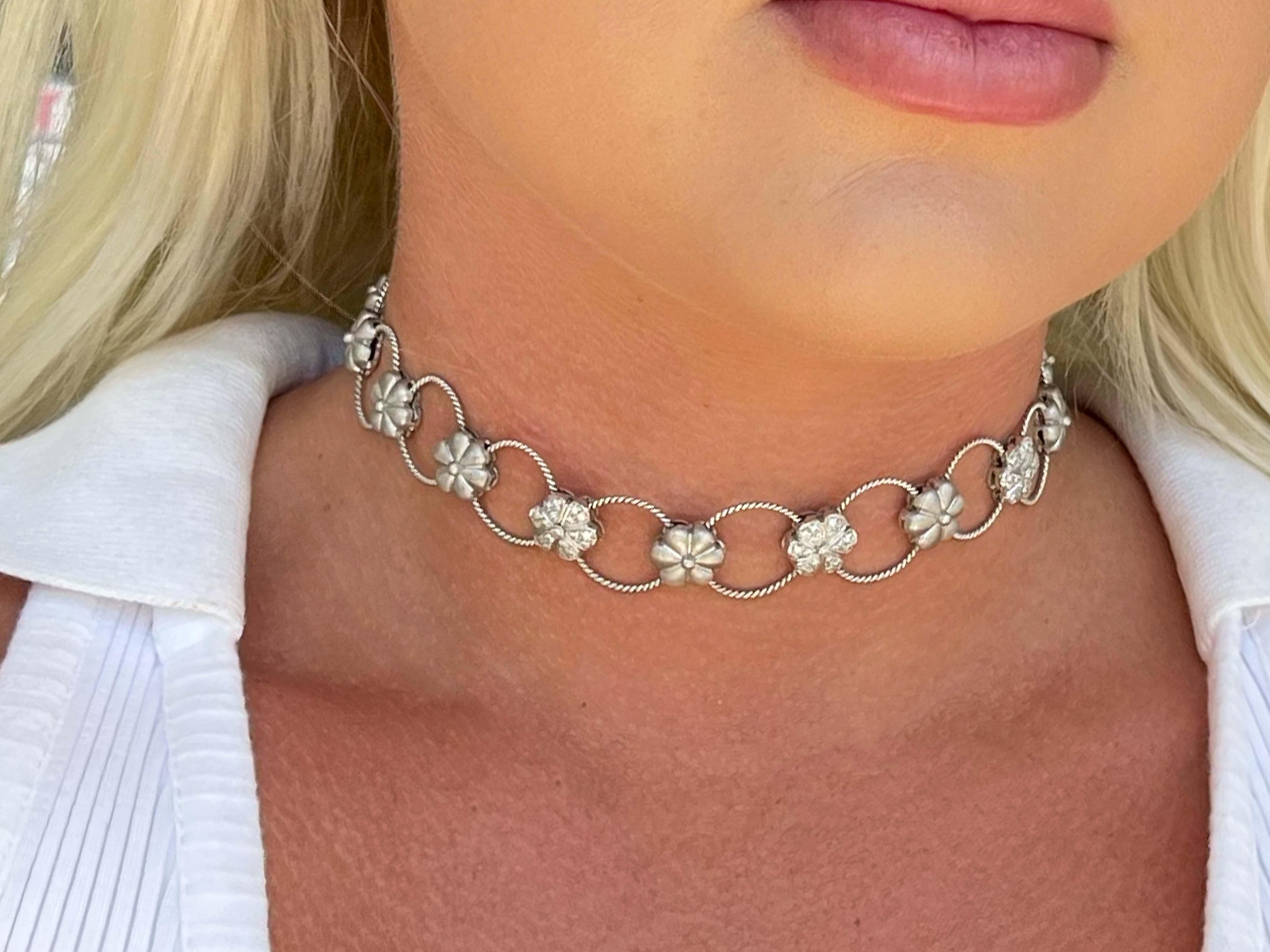 Stunning 18K white gold diamond choker necklace by Assor Gioielli. The magnificent design of this choker necklace features 14 cable design hoops connected together by 13 sand-blasted flower design sections with three sections pave' set with