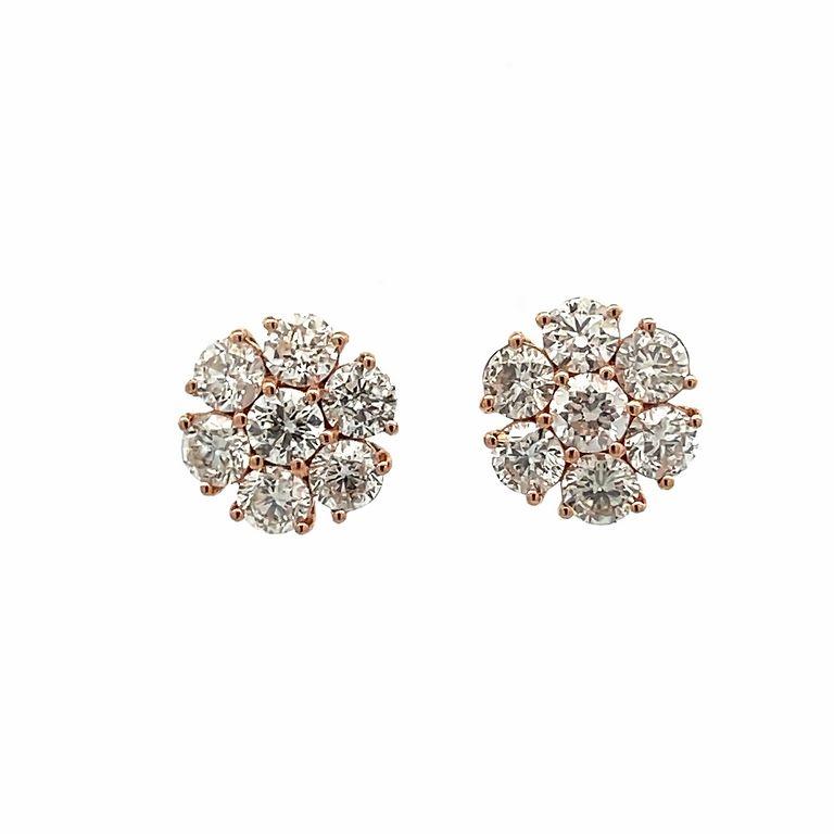 Indulge in the exquisite beauty of these stunning earrings that are sure to make a bold statement. These delicately crafted earrings feature a beautiful flower design made in 14K rose gold with white round diamonds. Each earring features 7 stones,