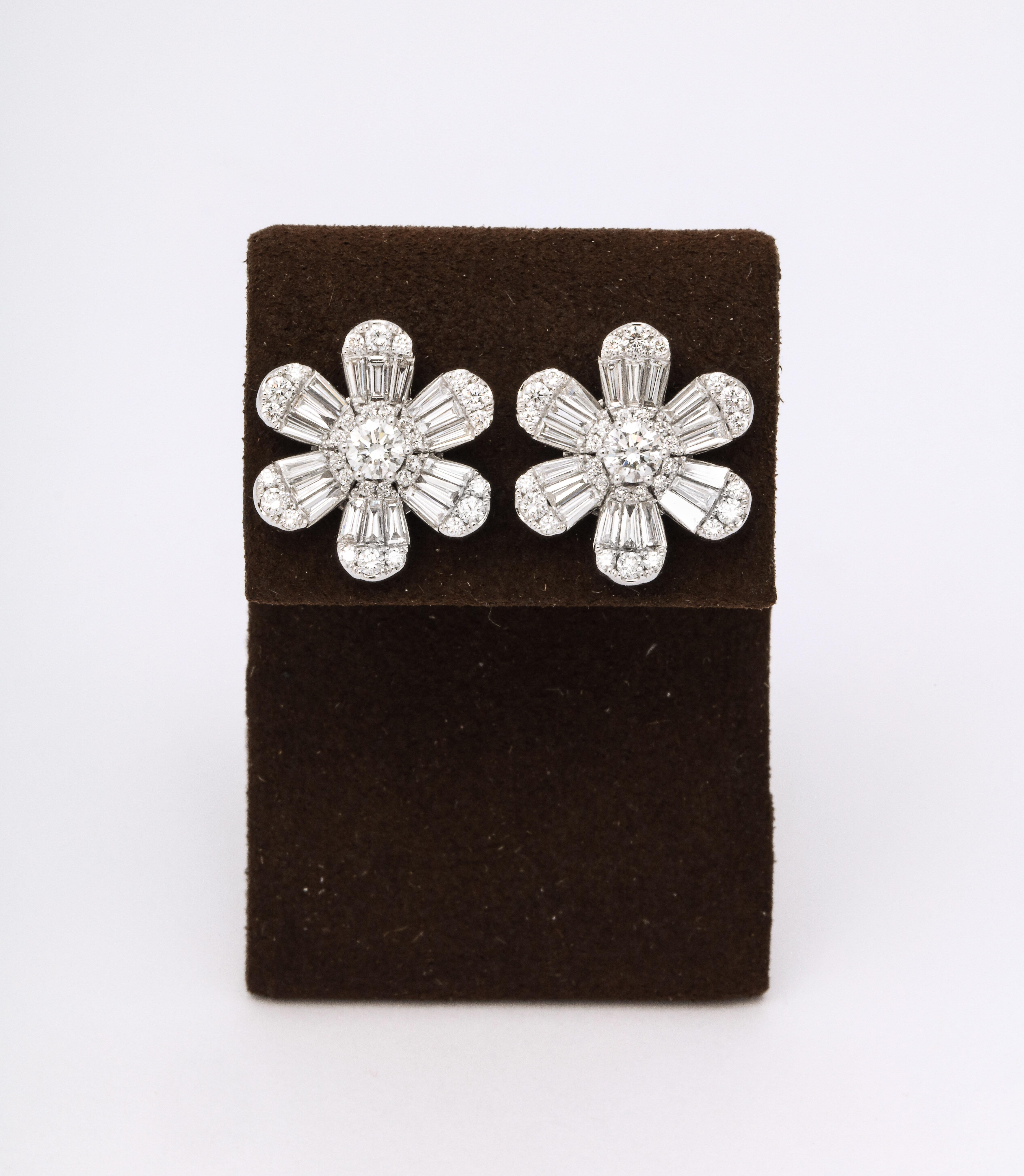 
Une magnifique paire de boucles d'oreilles en forme de fleur, les diamants de tailles différentes créent un éclat unique ! 

2,75 carats de diamants ronds et baguettes de couleur F et de pureté VS, sertis dans de l'or blanc 18k. 

Diamètre