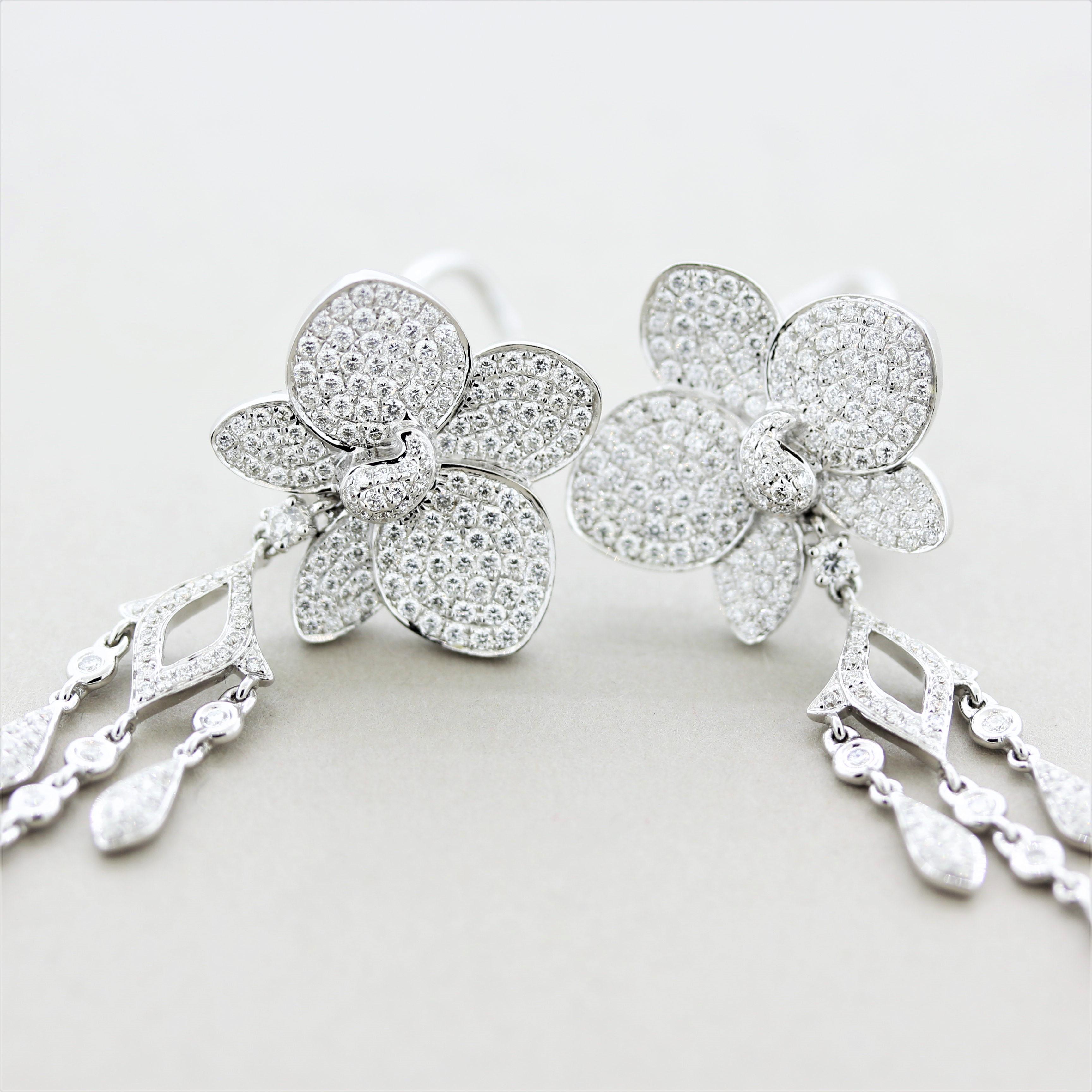 Un paio di orecchini eleganti con un grande movimento e una grande fluidità. Gli orecchini sono caratterizzati da 2,40 carati di diamanti rotondi a taglio brillante incastonati in un design floreale. La parte inferiore degli orecchini cade e penzola