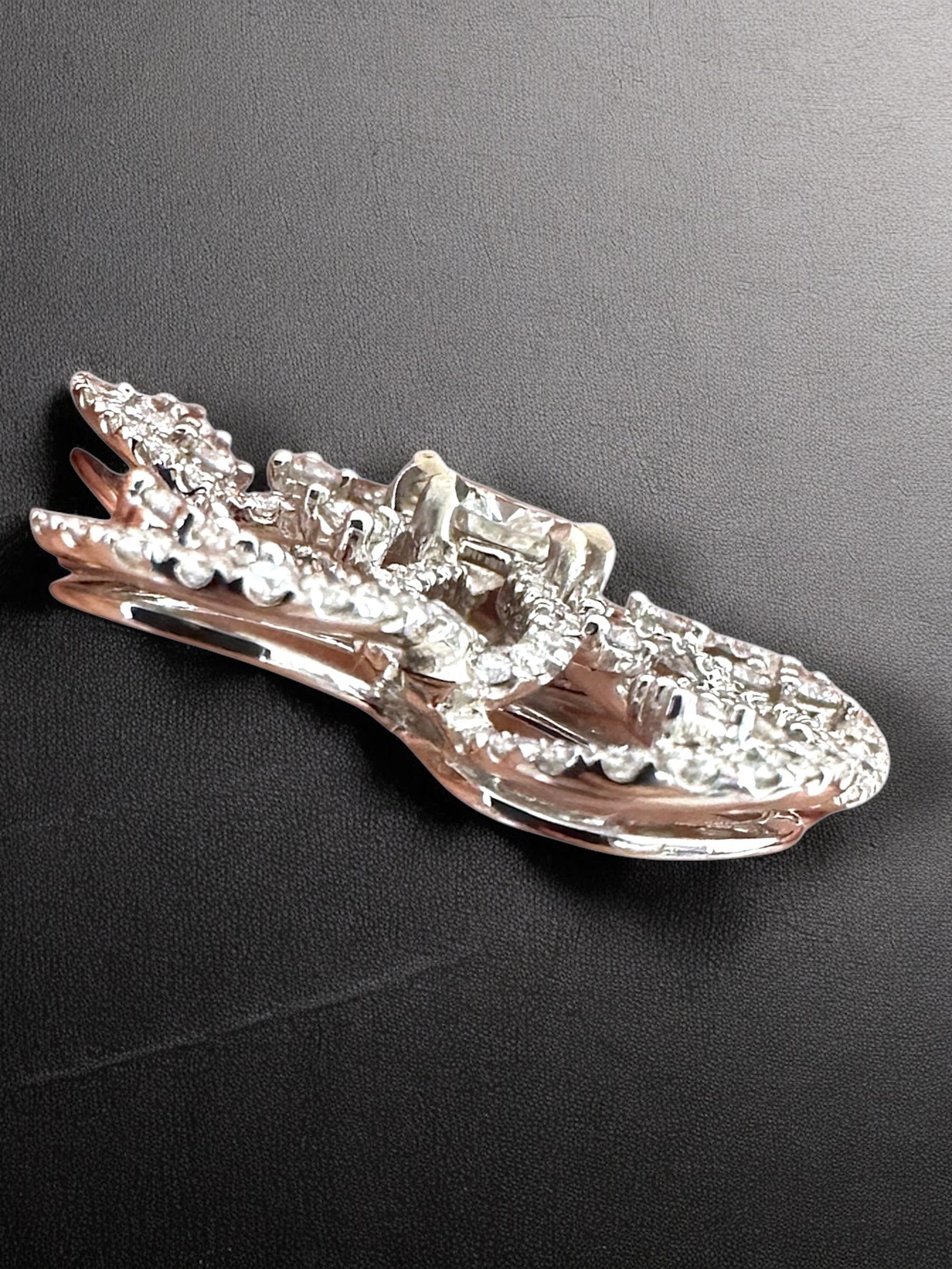 Questo squisito ciondolo è un'incredibile dimostrazione di maestria, con una disposizione ipnotica di diamanti che scintillano e danzano con ogni tuo movimento. Il design aperto e articolato crea una silhouette elegante e fluida che eleva qualsiasi