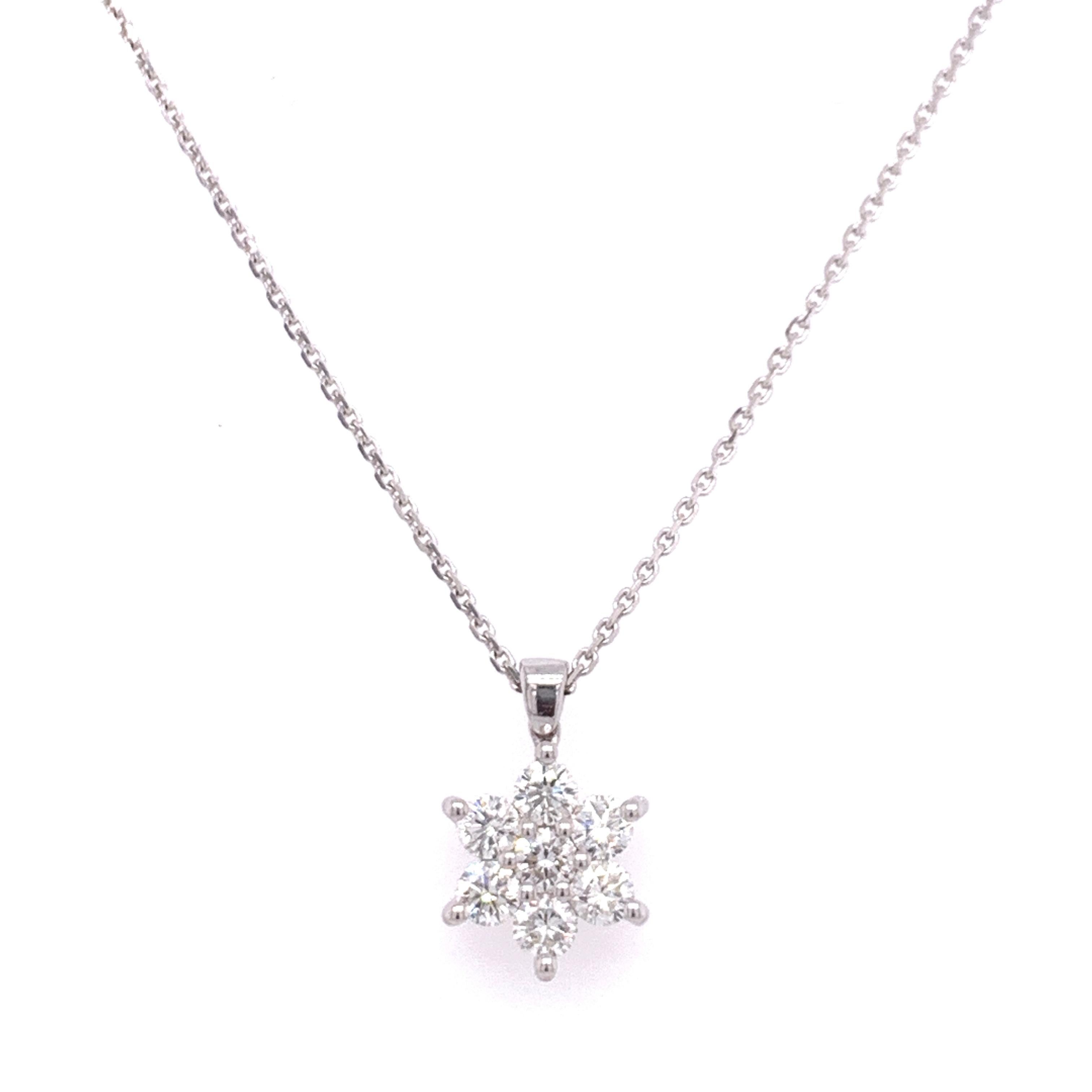 Flower shaped diamond pendant necklace made with natural/brilliant cut diamonds. Total Diamond Weight: 0.62 carats. Diamond Quantity: 7 round diamonds. Color: G. Clarity: VS. Mounted on 18 karat gold adjustable chain.