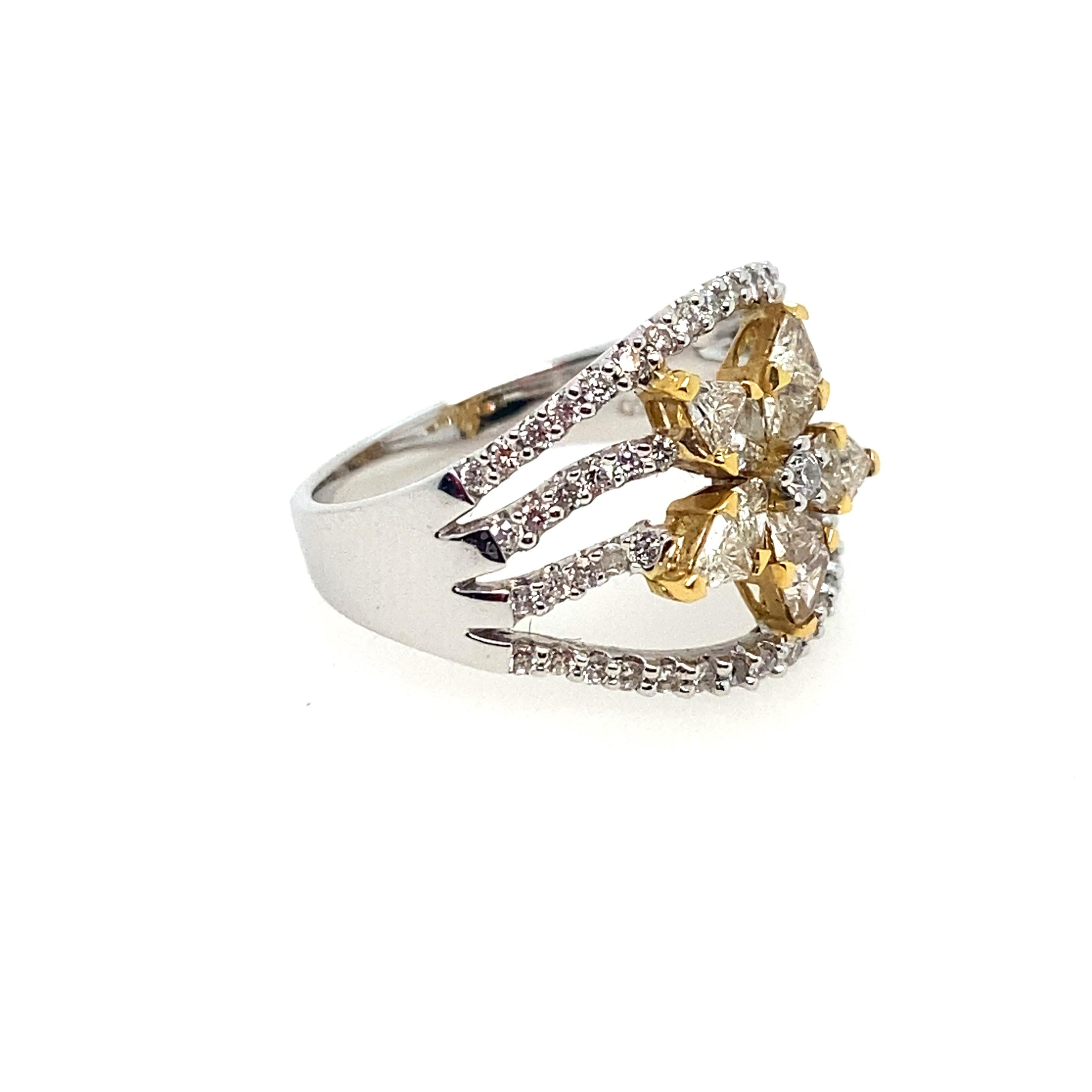 Diamond Flower ring in 18kt two-tone gold.  The wide band ring weighs 5.8 grams.  It has pale, natural yellow diamond petals, and white round diamonds going down the shank, in a split band design.  The total weight of these diamond is 0.94cts.  The