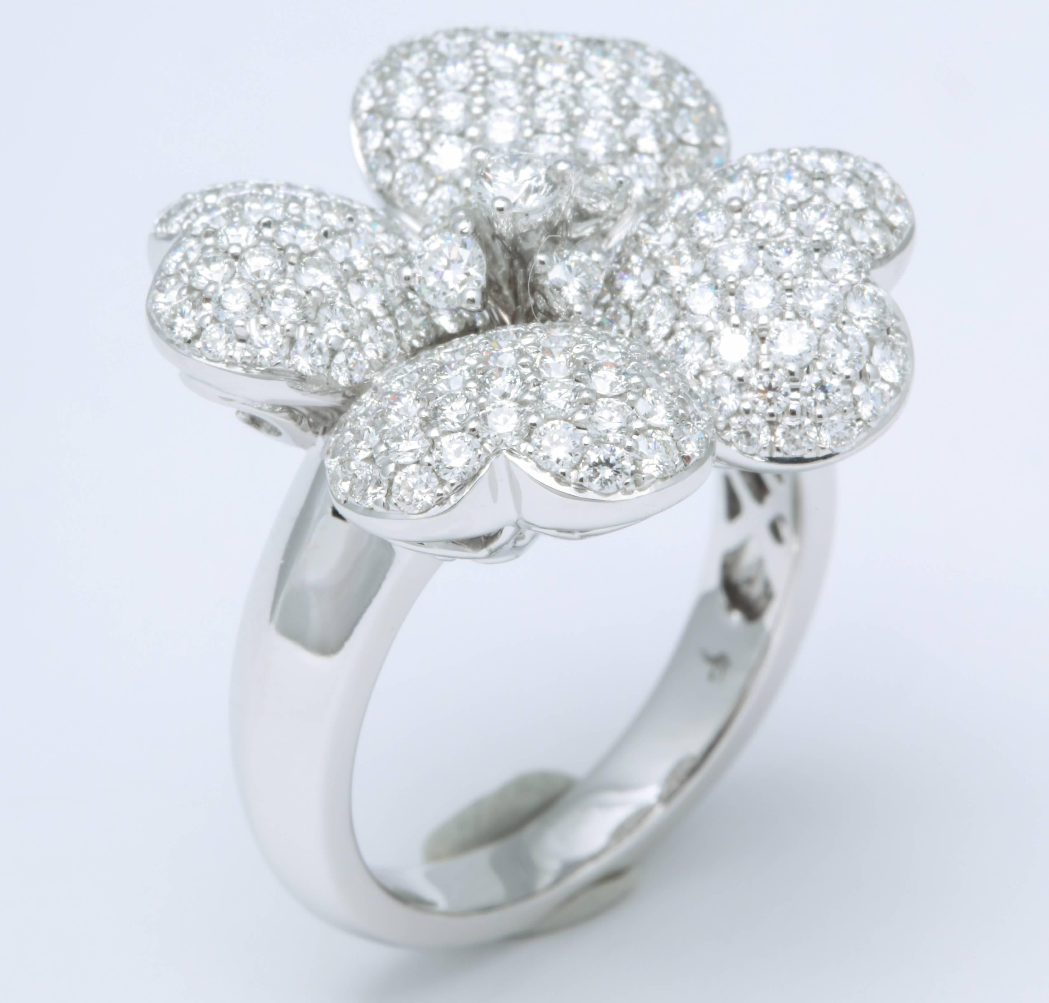 
So much sparkle set into a beautiful and iconic flower design.

2.15 carats of F color VS round brilliant cut diamonds set in 18k white gold. 

Currently a size 6.5 but can be sized to any finger size. 

Approximately .80 inches in diameter. 

The