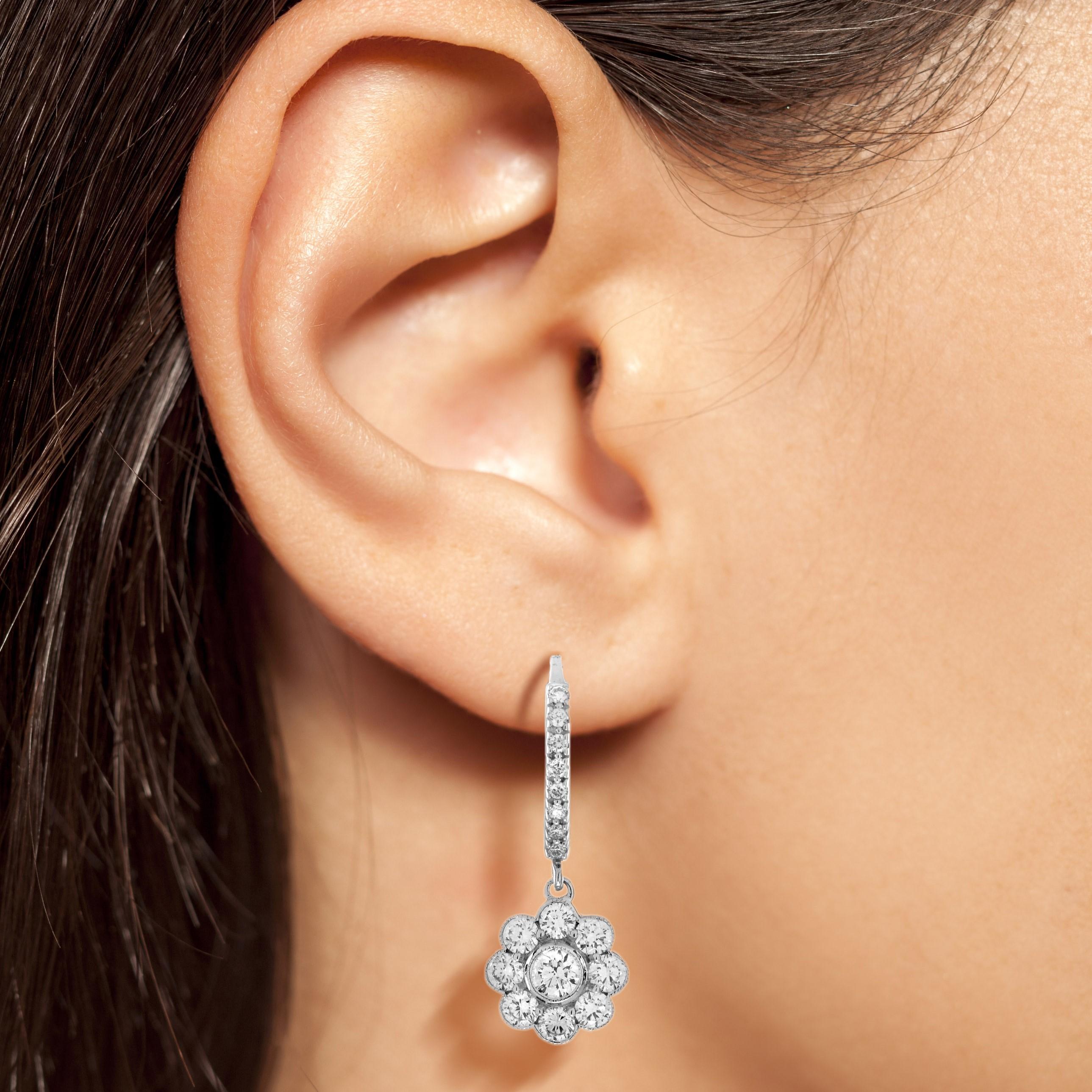 Round diamonds create the eight petals in this intriguing vintage inspired flower earrings. A  3.5 mm. round diamond is set in the center for the flower design. This is an Edwardian style daisy flower earrings that has remained popular since early
