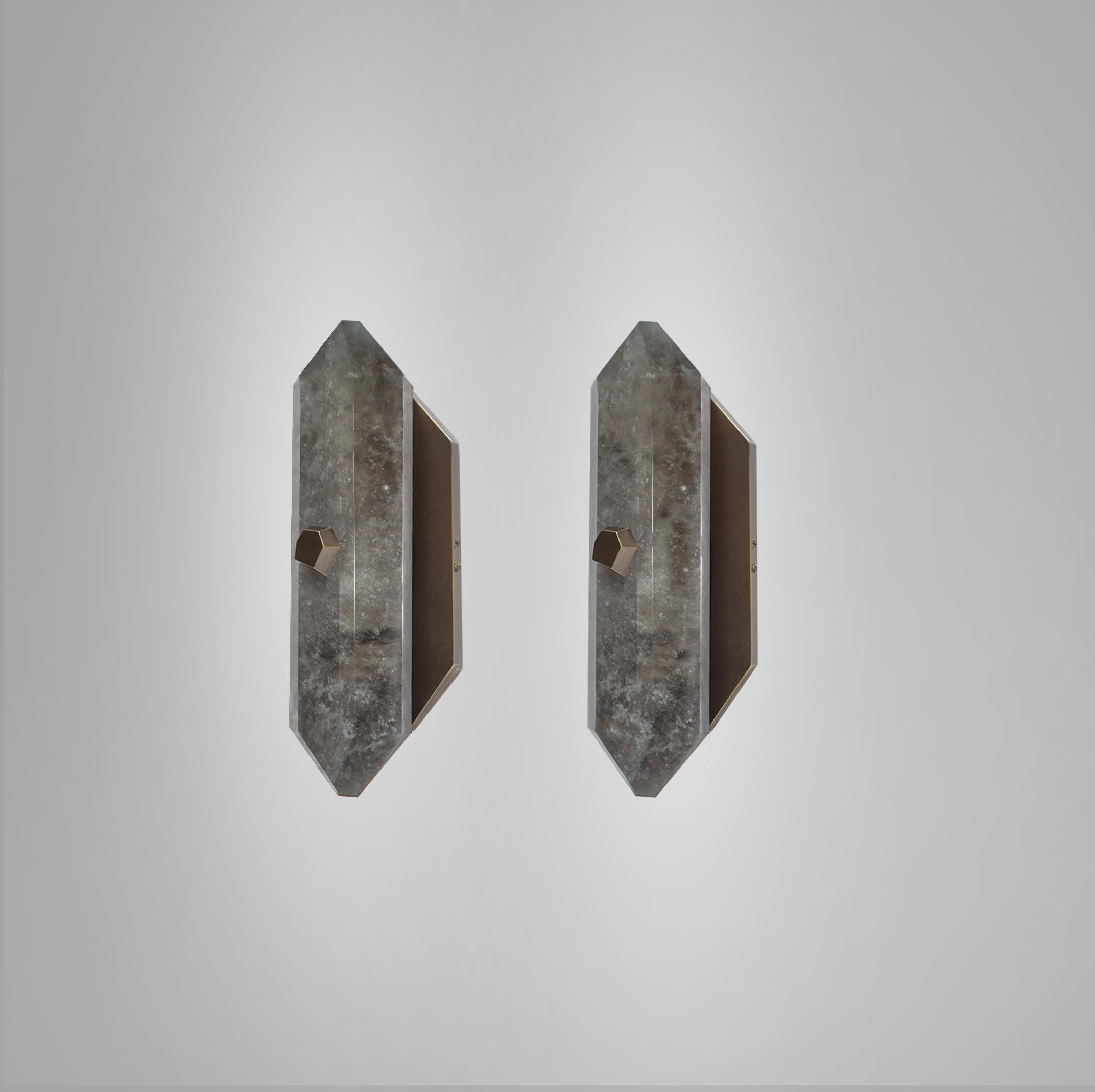 Pair of finely carved diamond form smoky rock crystal quartz wall sconces with diamond form antique brass finish bolts. Created by Phoenix Gallery.
Custom measurement, finish, and quantity upon request. 
Each sconce installed two sockets. 60 watts