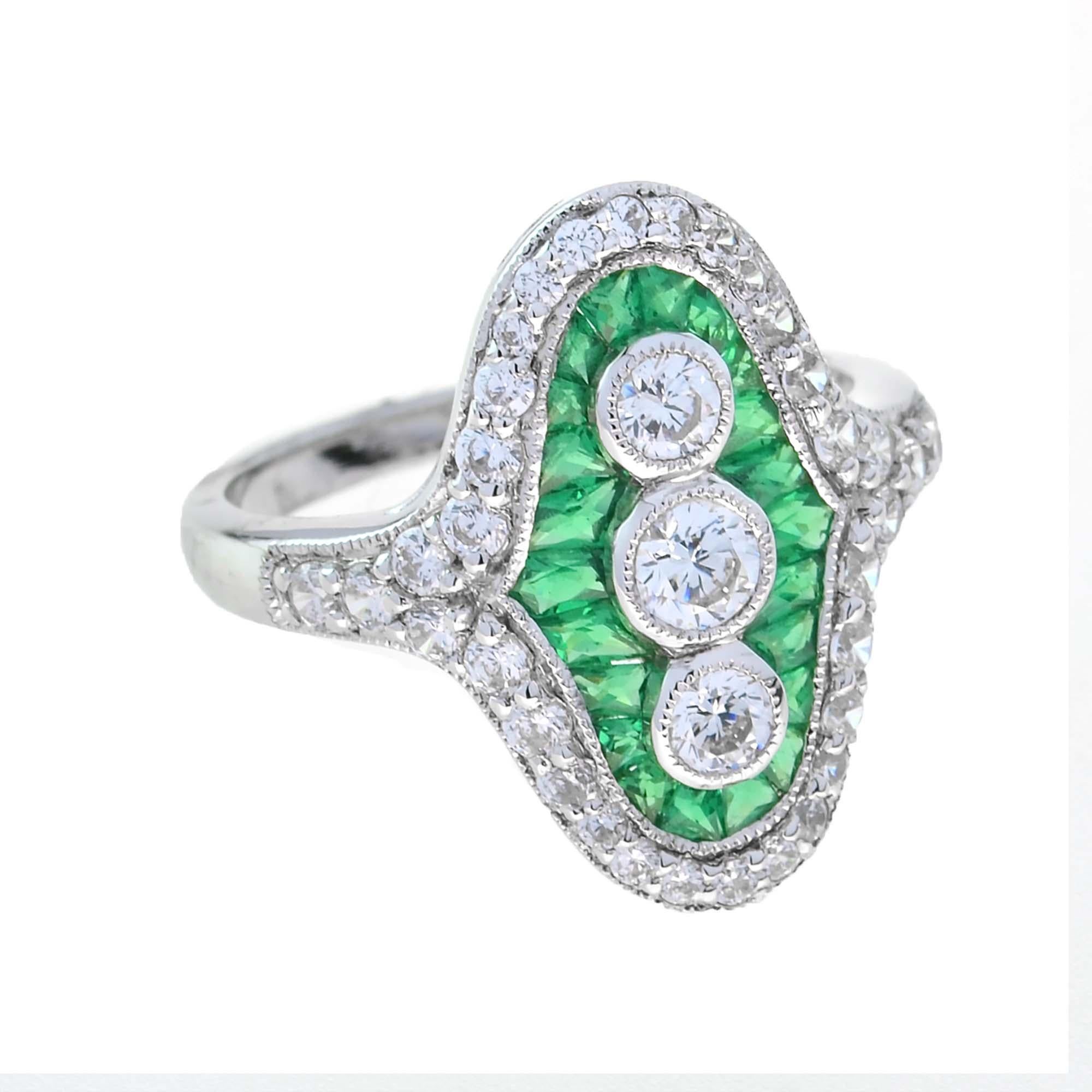 Prova un'eleganza senza pari con l'anello a tre pietre con diamante e smeraldo taglio francese. Al centro, tre splendidi diamanti rotondi sono splendidamente incorniciati da squisiti smeraldi taglio francese, che aggiungono un vibrante tocco di