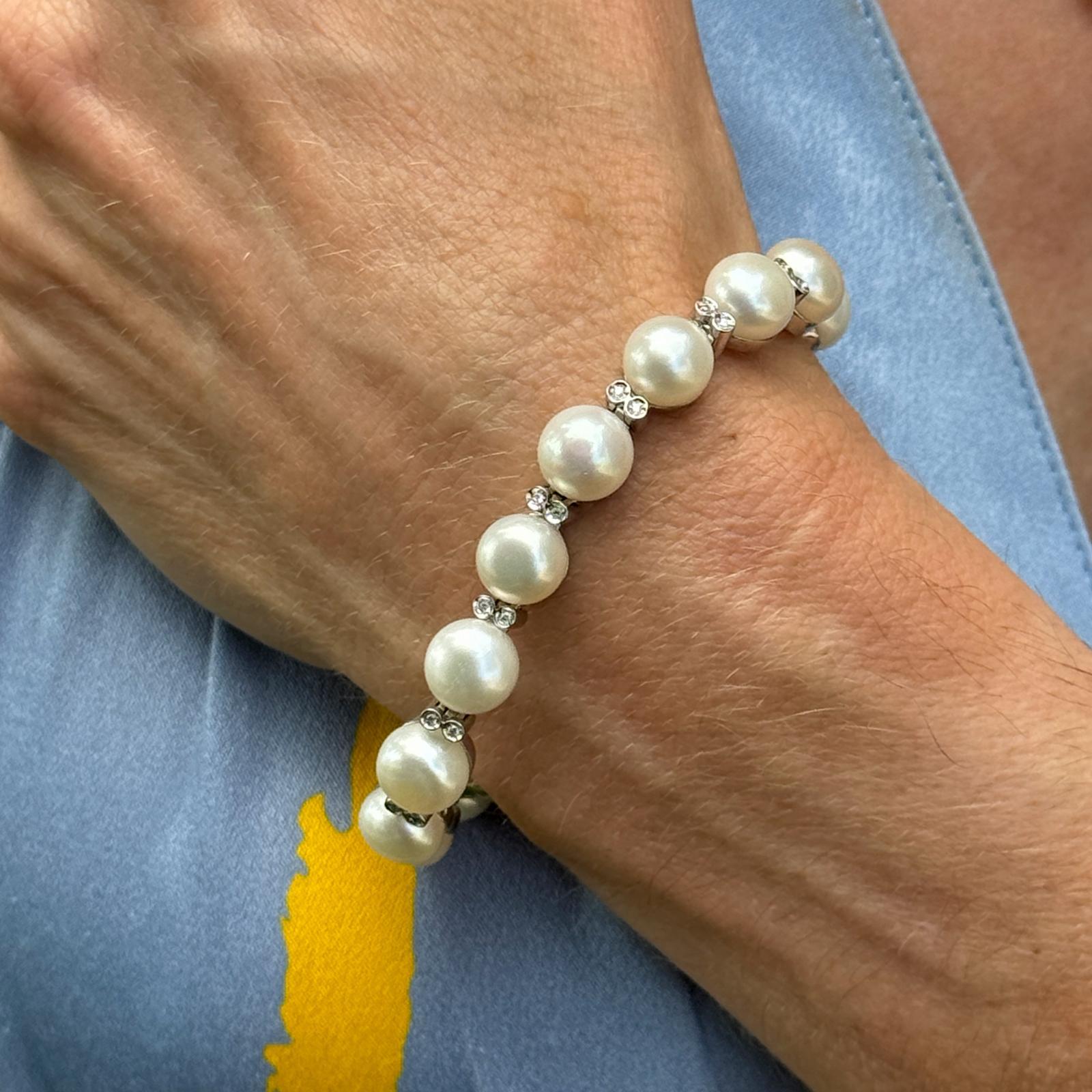 This elegant bracelet is crafted from 14 karat white gold, featuring 32 round brilliant diamonds with a total weight of 0.33 carats, graded H-I in color and SI in clarity. The diamonds are beautifully complemented by lustrous freshwater cultured