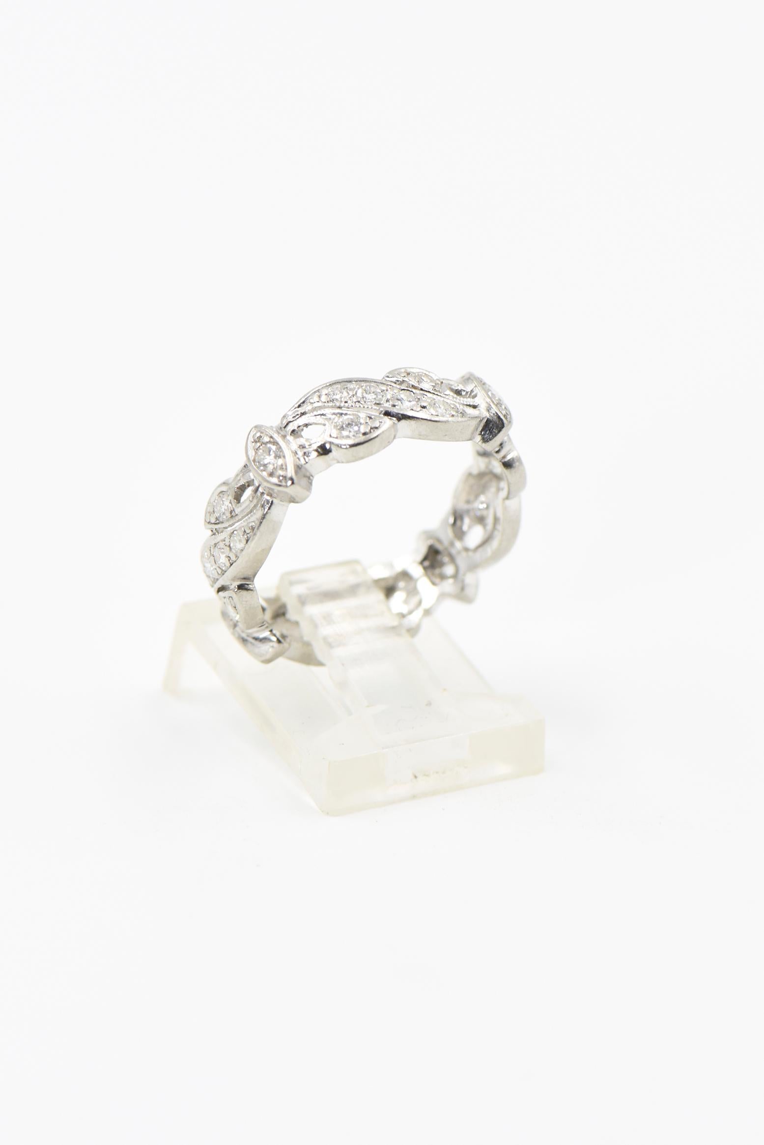 Garland style diamond eternity band featuring alternating sections one with a diamond in a marquis shaped plaque and the other with swag and vine design.  There are 4 sections of each containing a total of 28 diamonds.  The approximate total diamond