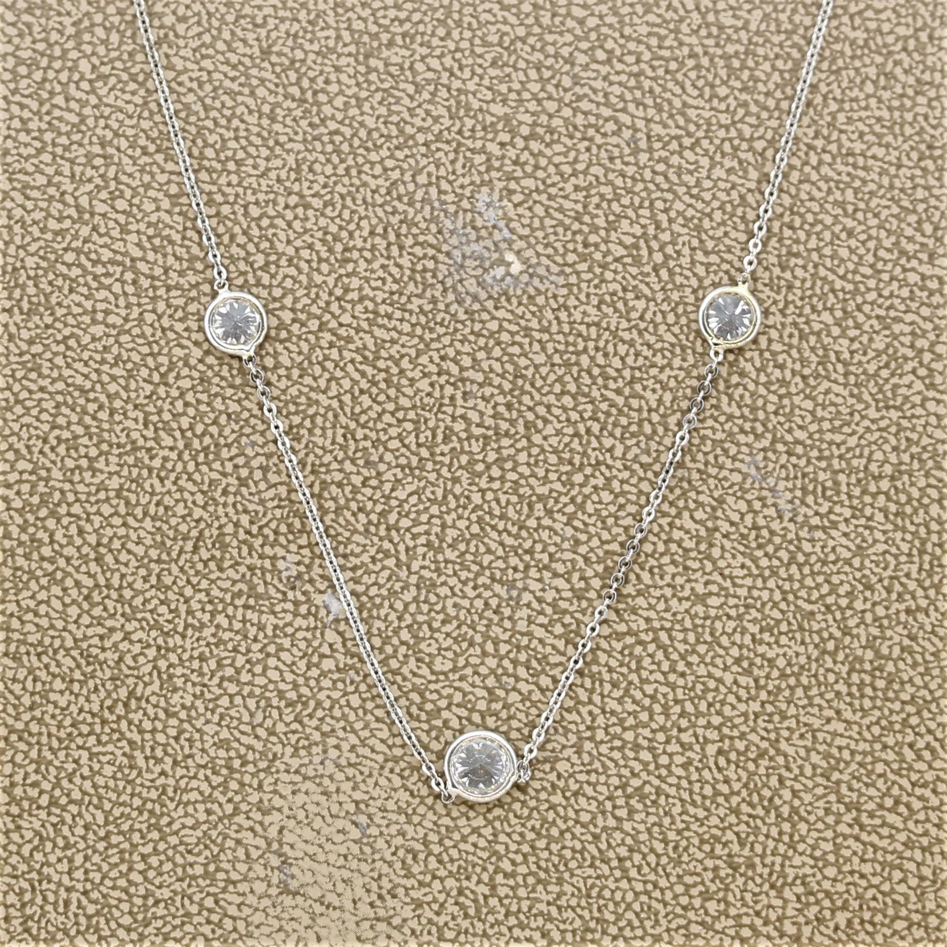 A simple yet elegant necklace featuring 3 round brilliant cut diamonds. The diamond in the center is larger than the two on its sides and together they weigh 1.00 carat. They are bezel set in 18k white gold and set 2-inches apart. Made in 18k white