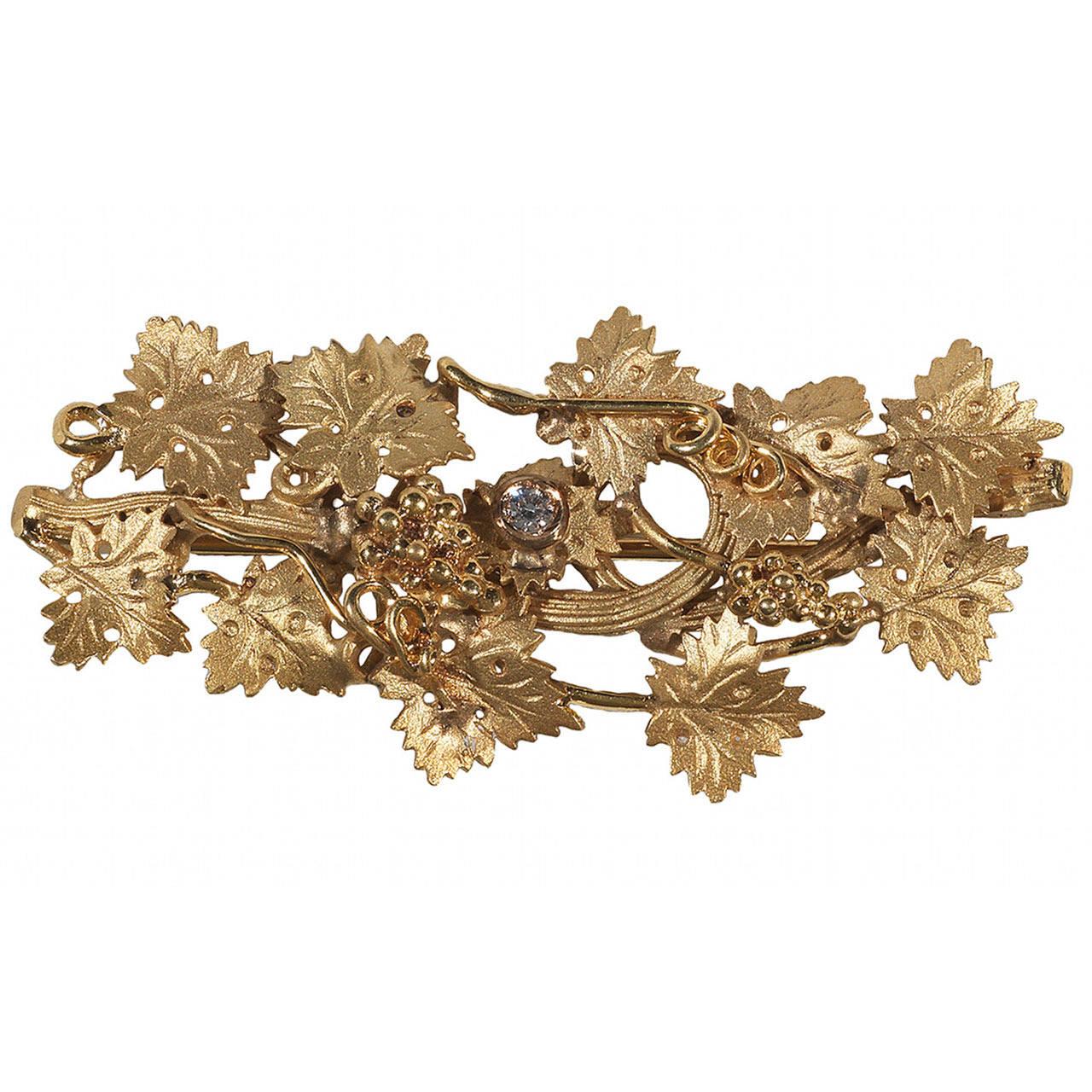 
A brooch of leaves and a bunch of grapes design. 
Mounted in 18Kt Gold

50 mm wide
23 mm high
Weight: 9.7 gr