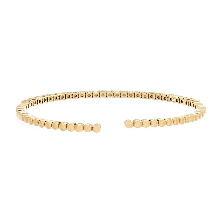 Inspired by the tennis bracelet, this cuff features 1.63 carats of brilliant round cut diamonds with a traditional four prong setting all done in 18K yellow gold. With gold beading half way around and an open space for easy access, this cuff is