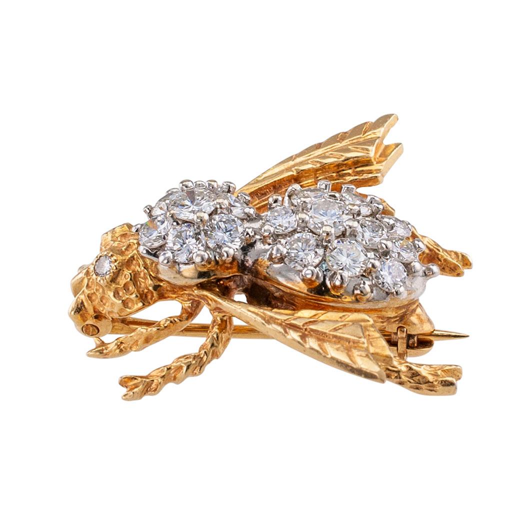 Diamond and gold bee brooch circa 1980. The honeybee brooch has diamond-set eyes, its body set with more diamonds and the head, legs and wings in yellow gold decorated with organic motifs relevant to a bee’s body, the diamonds totaling approximately