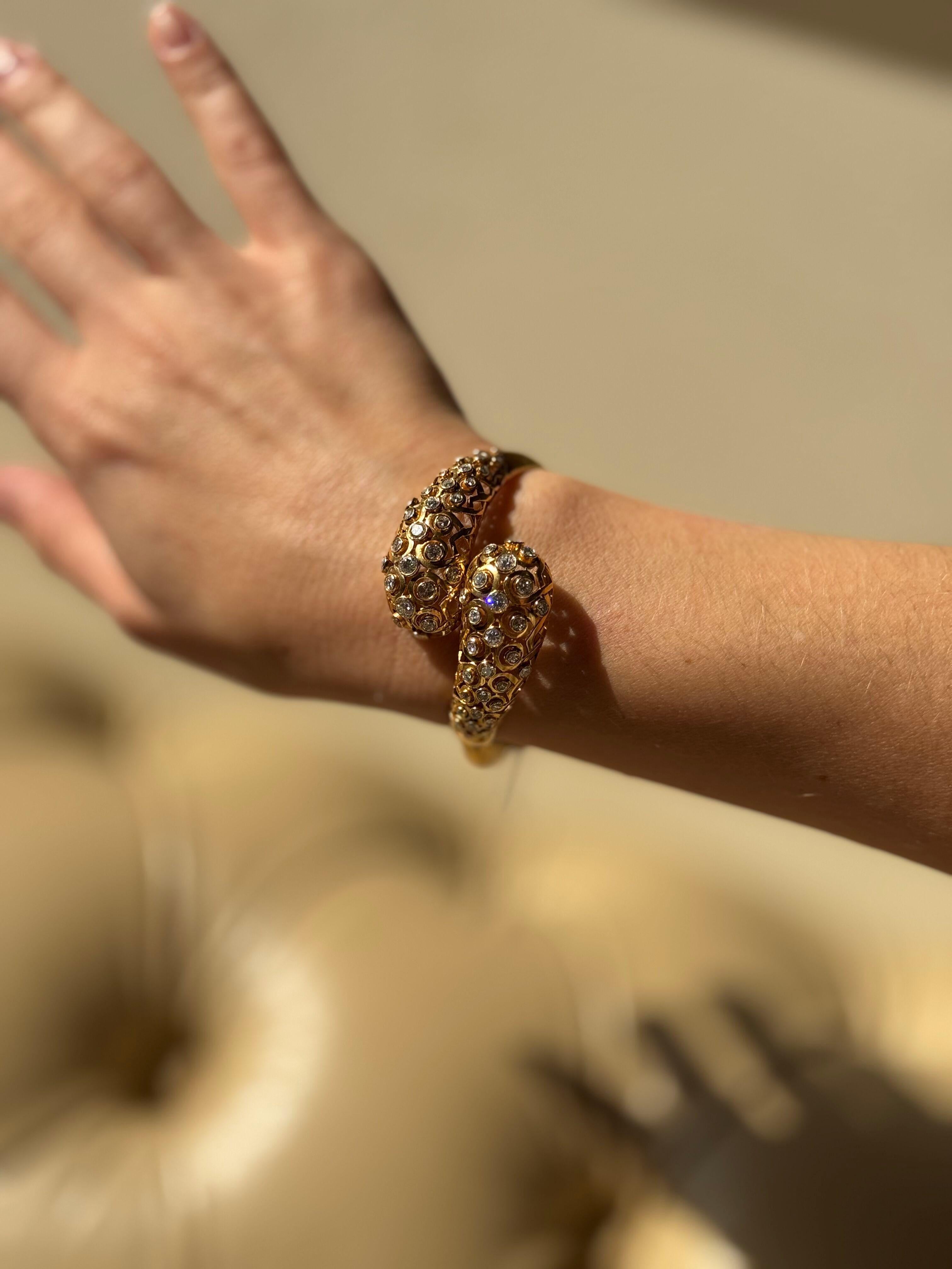 Pulsera bypass de oro amarillo de 18 quilates, con aproximadamente 4,00 ctw de diamantes H/SI1.

La pulsera se ajusta a una muñeca de aprox. 15 cm y el centro mide 1,25 cm de ancho.

Sello de calidad en la lengüeta del cierre.

Peso - 30,1 gramos