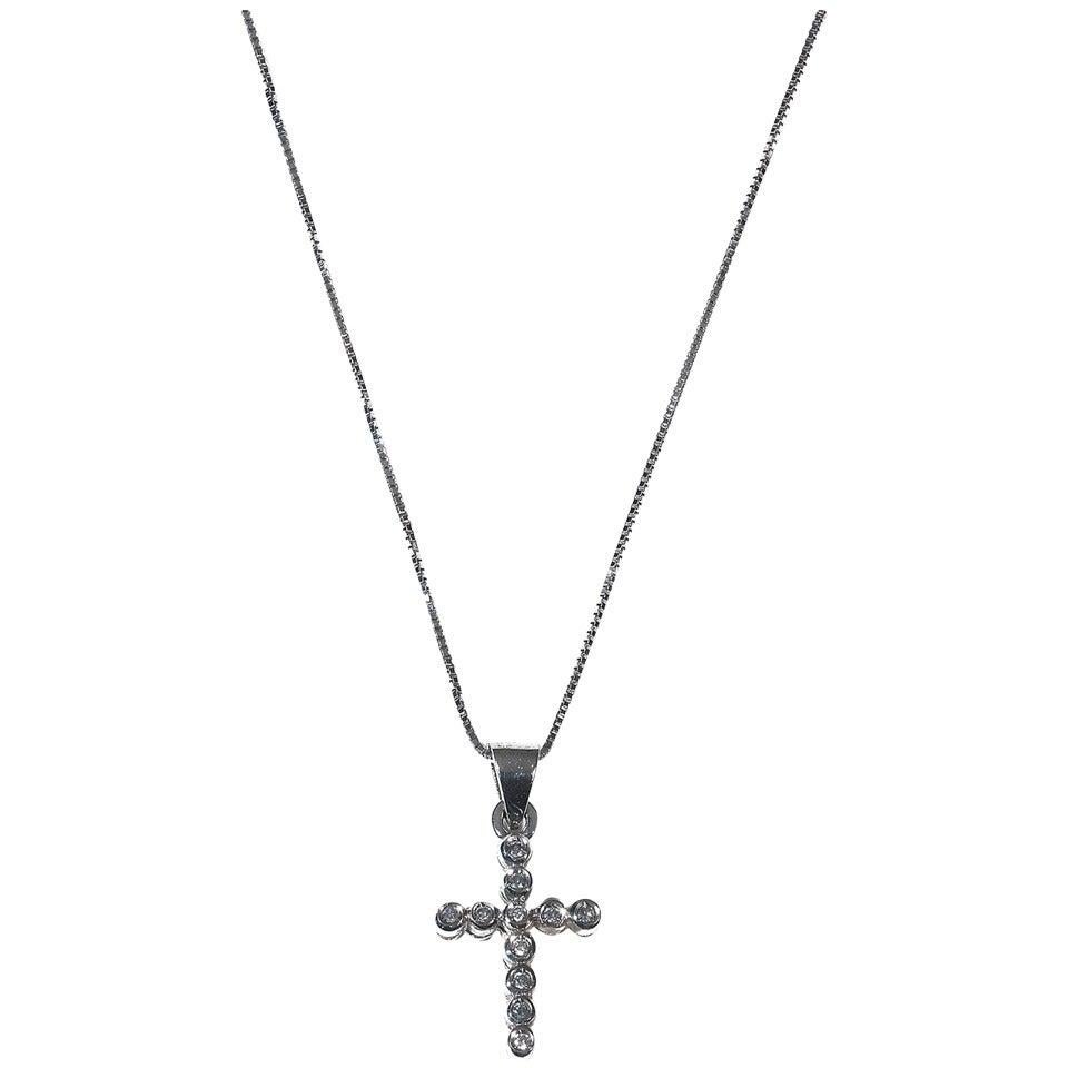 Designed as a cross set throughout with eleven round-cut diamonds to a 18Kt white gold venetian link chain 

Mounted in 18Kt white gold.

Lenght of the chain: 45.5 cm

The cross: 16 mm long