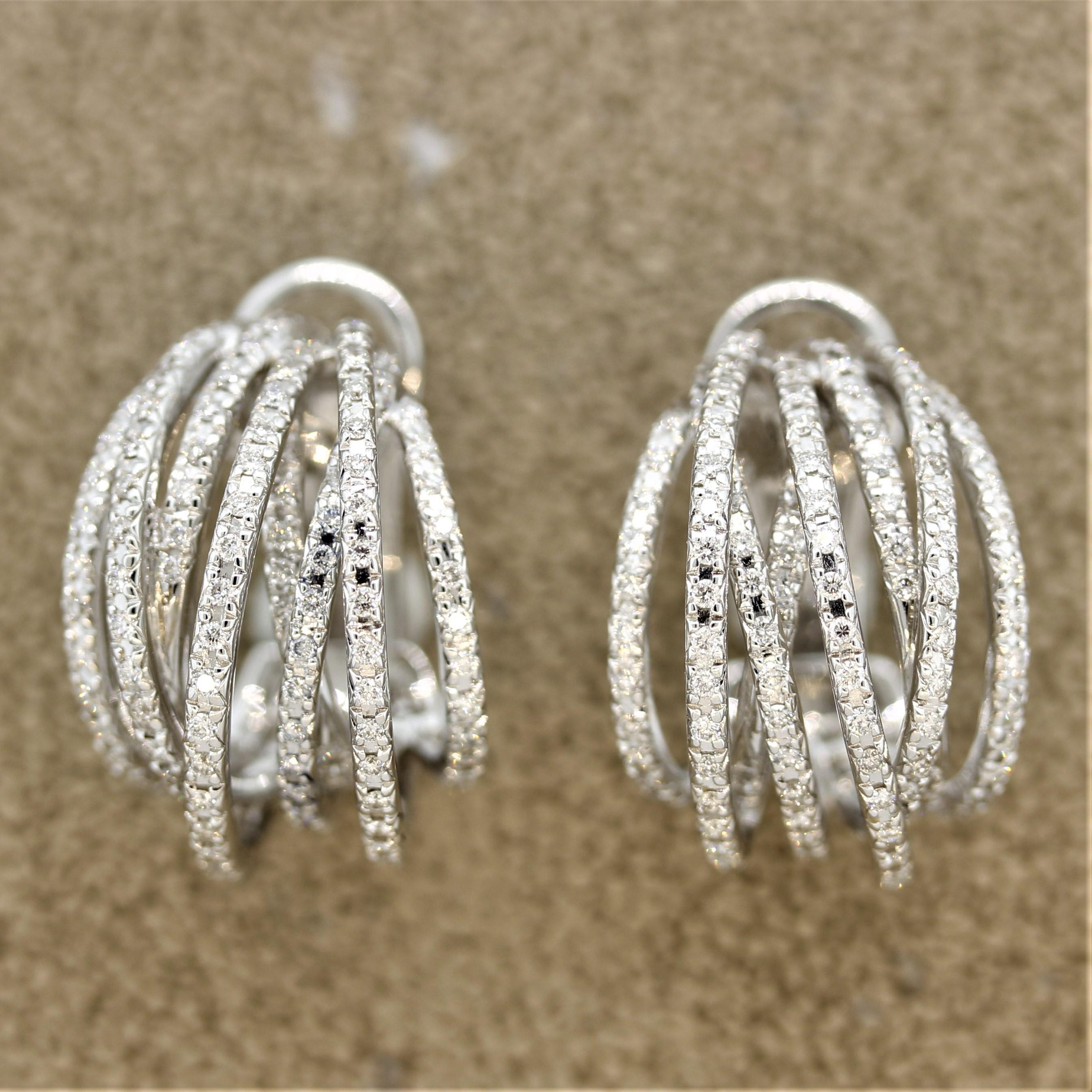 A lovely pair of earrings made in 18k white gold. They feature 1.76 carats or round brilliant cut diamonds which are set one after another over lines of white gold which crossover each other. This adds dimension to the stylish earrings. Made in 18k