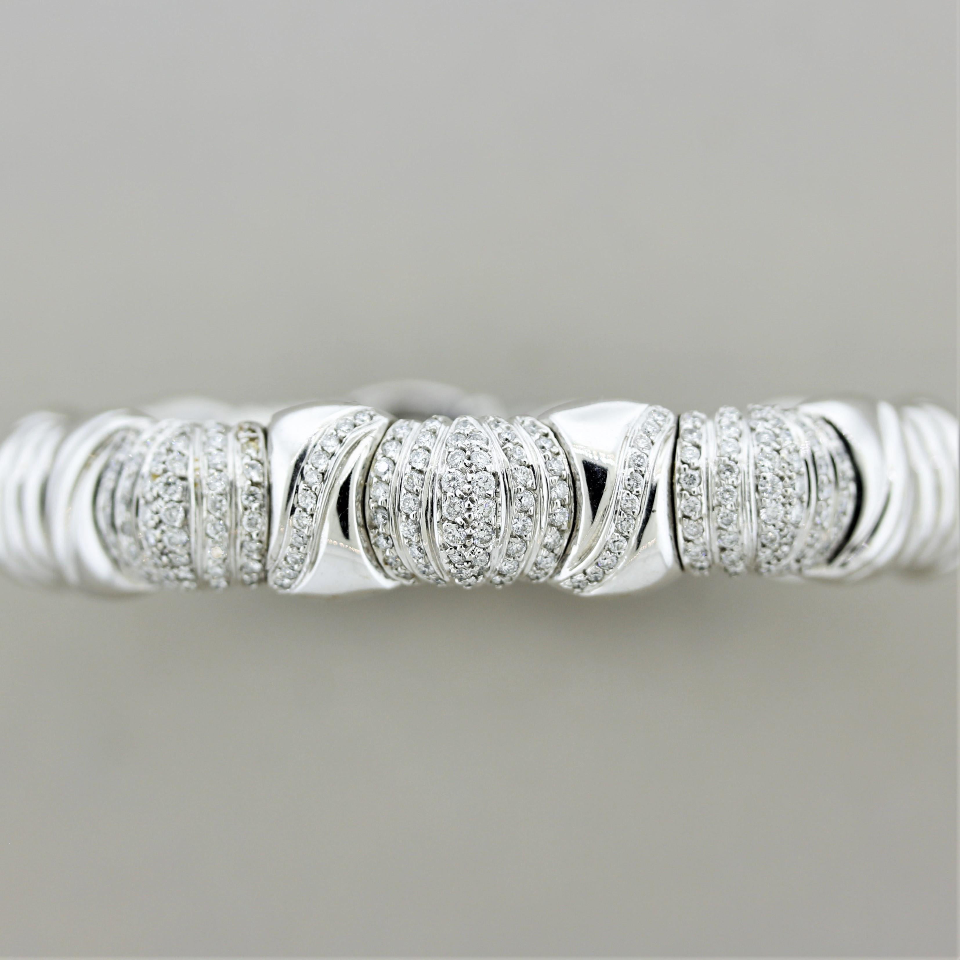 A white gold cuff bracelet with 1.70 carats of round brilliant-cut diamonds. They are set in vertical rows in the center of the bracelet with the same design emulated in gold throughout the piece. Made in 18k white gold with some stretch at its