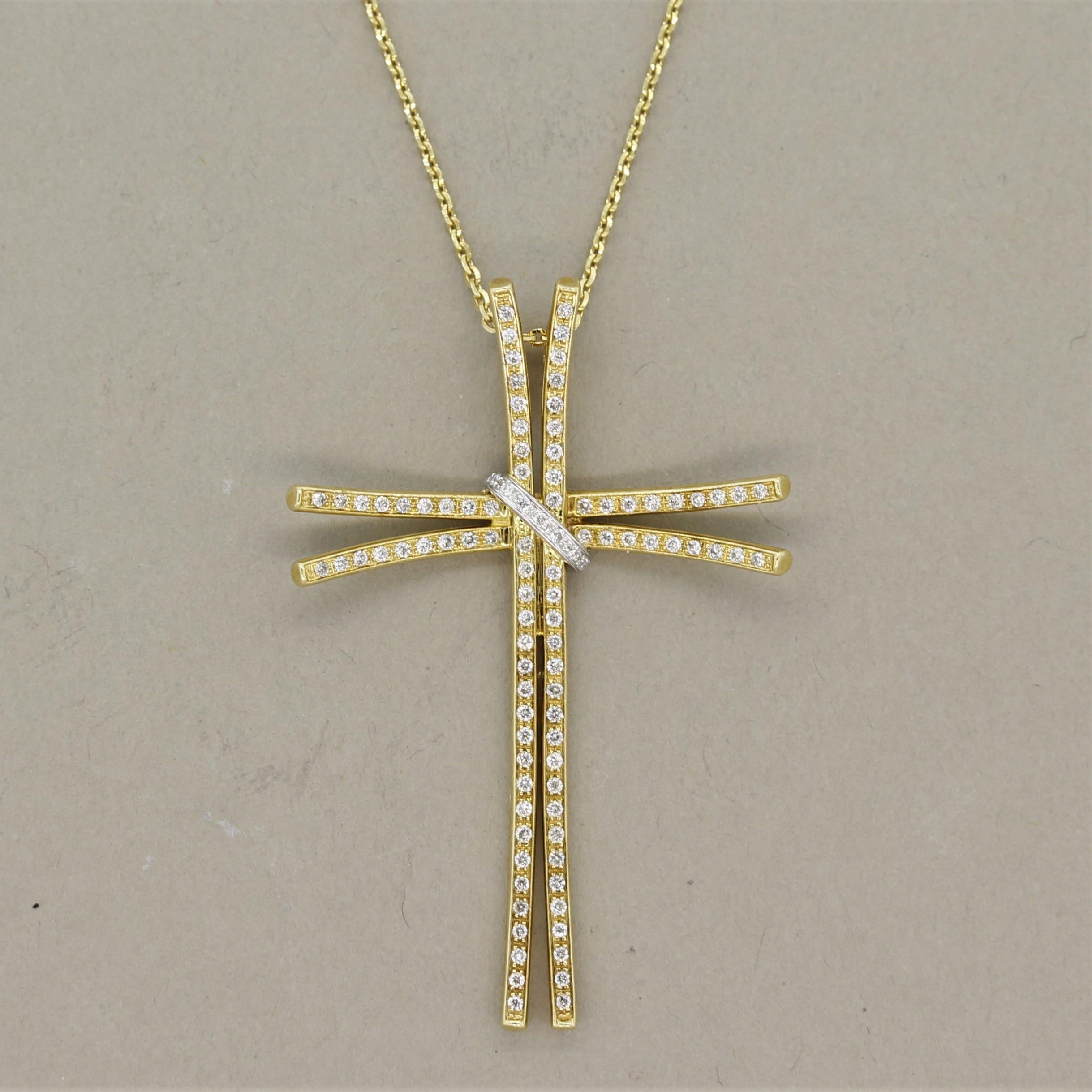A unique take on the classic cross pendant. This cross features 0.42 carats of round brilliant cut diamonds set over 18k yellow gold along with a white gold tie that adjoins the crosses at their meeting point. This adds a slight two-tone gold look