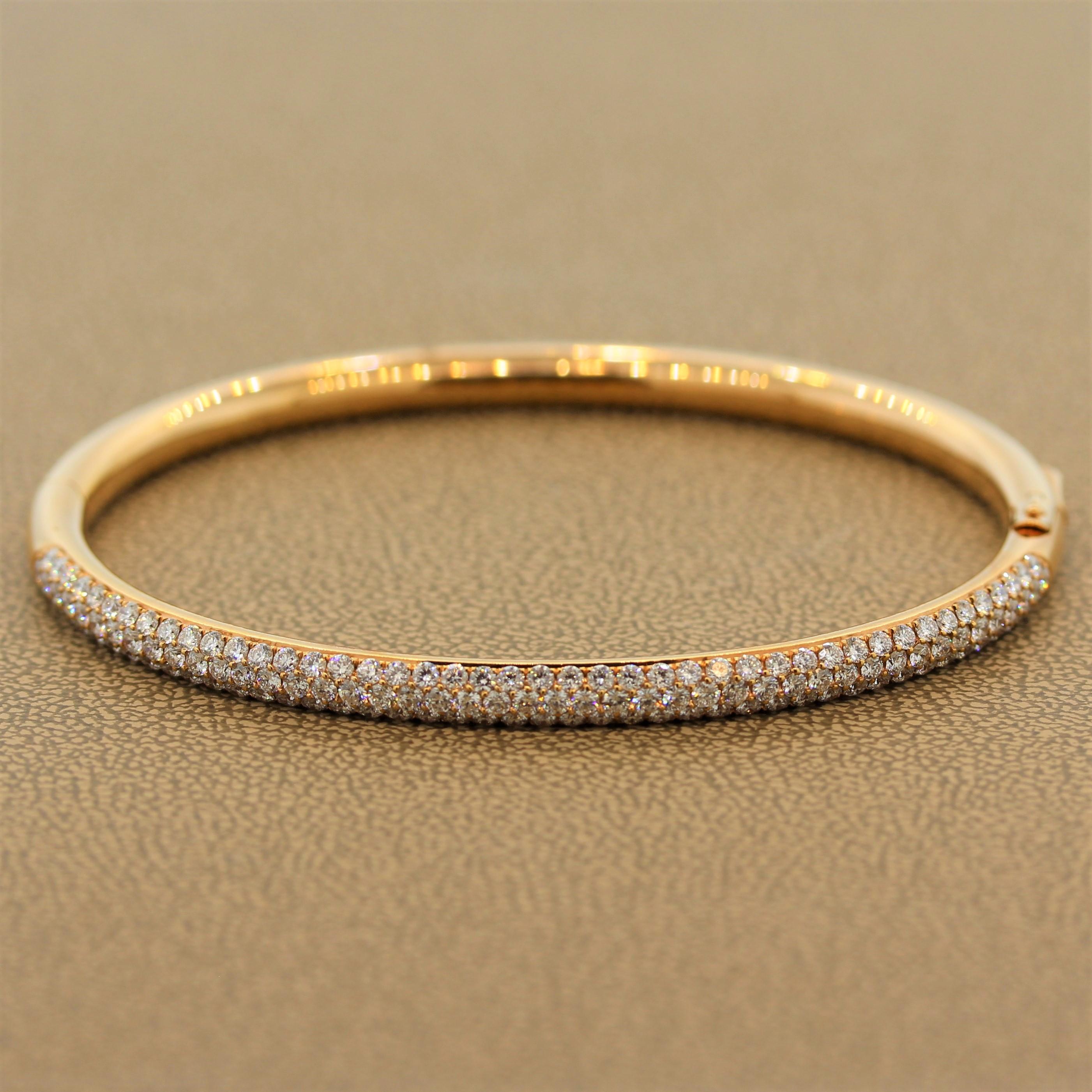 A hard bracelet with timeless elegance featuring 2.86 carats of VS quality diamonds. The colorless pave set diamonds are set in an 18K rose gold with a slight oval shape to adhere to the natural shape of the wrist. The diamonds are set halfway on