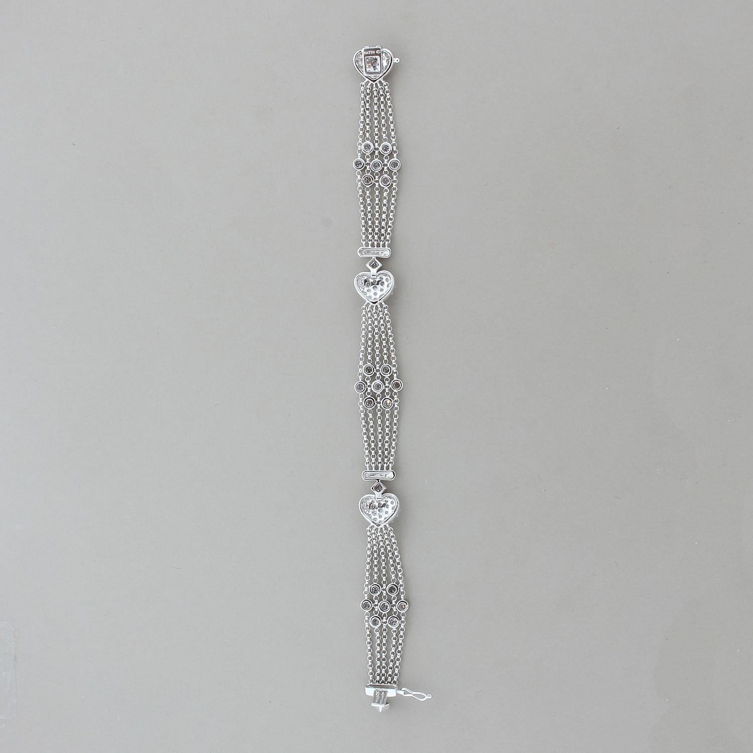 This meticulously crafted bracelet features 2.84 carats of diamonds set in an 18K white gold mesh setting. The round cut diamonds are pave set in heart shapes alternating five gold strands expertly strung to create floral clusters of bezel set
