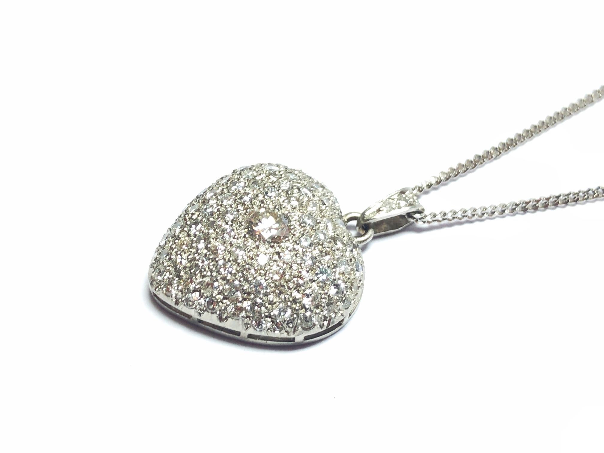 A small diamond heart pendant, with pavé set round brilliant-cut diamonds, with a total diamond weight of approximately 1.07ct, mounted in platinum, with a French dog head mark for platinum. With an 18ct white gold chain, with a British import