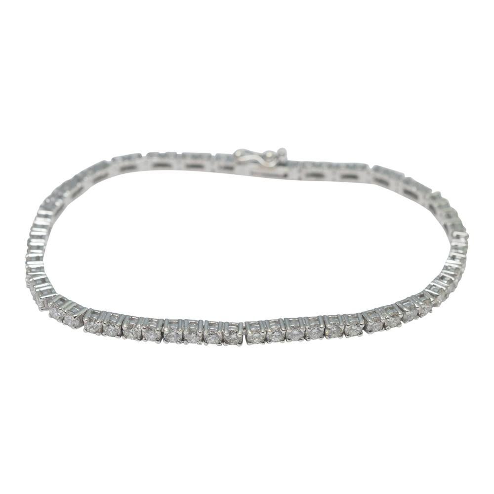 Classic brilliant cut diamond line bracelet in 18ct white gold; the bracelet is formed of pairs of diamonds linked together and claw set, totalling 5cts.  There are 62 diamonds in total.  It is fitted with a 