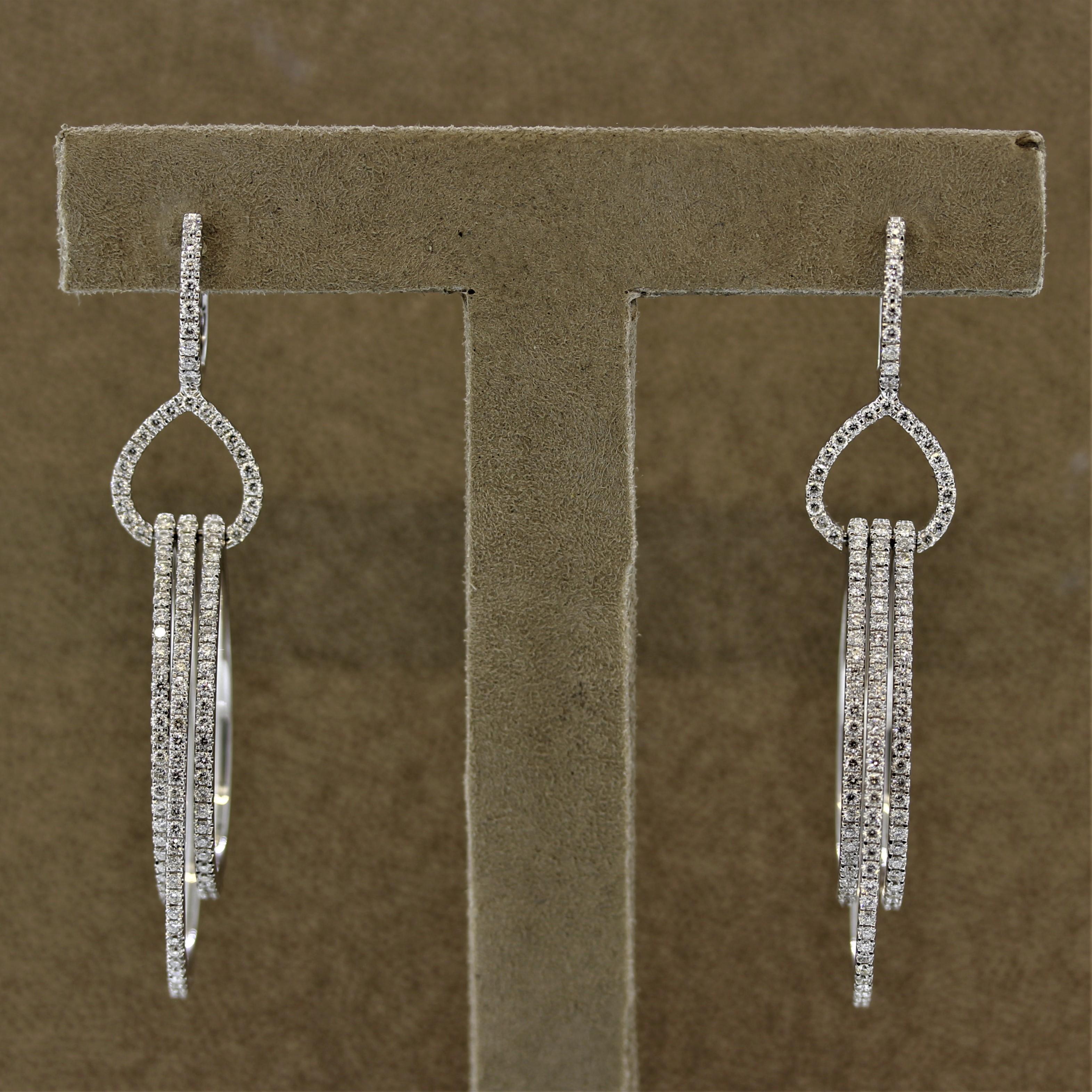 A unique pair of earrings which feature 3 pear shaped “hoops” on the bottom of the earrings which swing and dangle independently from one another. They are set with a total of 1.64 carats of round brilliant cut diamonds, made in 18k white gold.