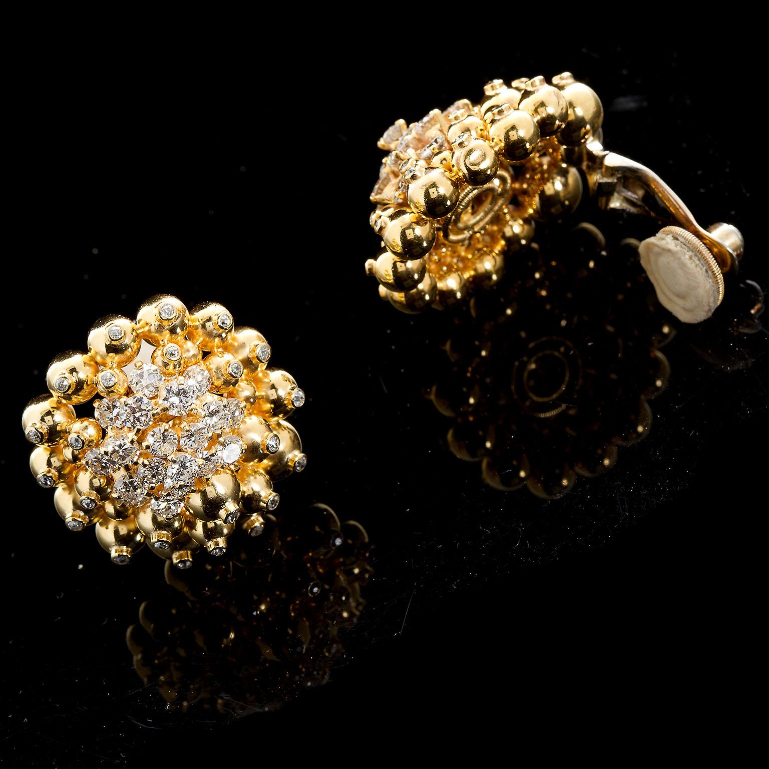 A cheerful vintage diamond in 18k yellow gold cluster earrings. Earrings are fashioned from a cluster of diamond tipped ornaments and garnished with a spray of melee diamonds. Each ear clip features a center diamond cluster of 19 very fine round