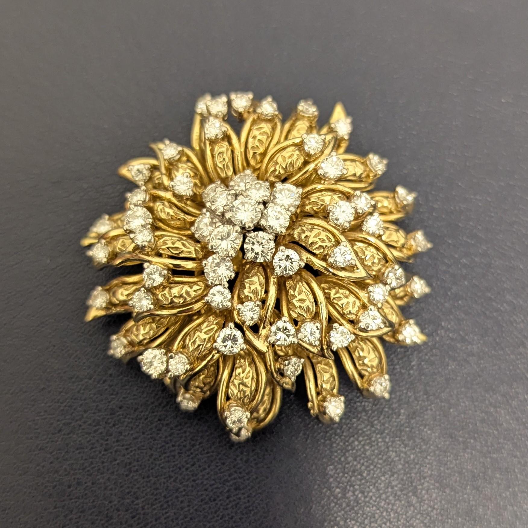 Este broche flor tiene 57 diamantes de color G-H y claridad VS engastados en oro y platino delicadamente trabajados. También se puede llevar como colgante. 

