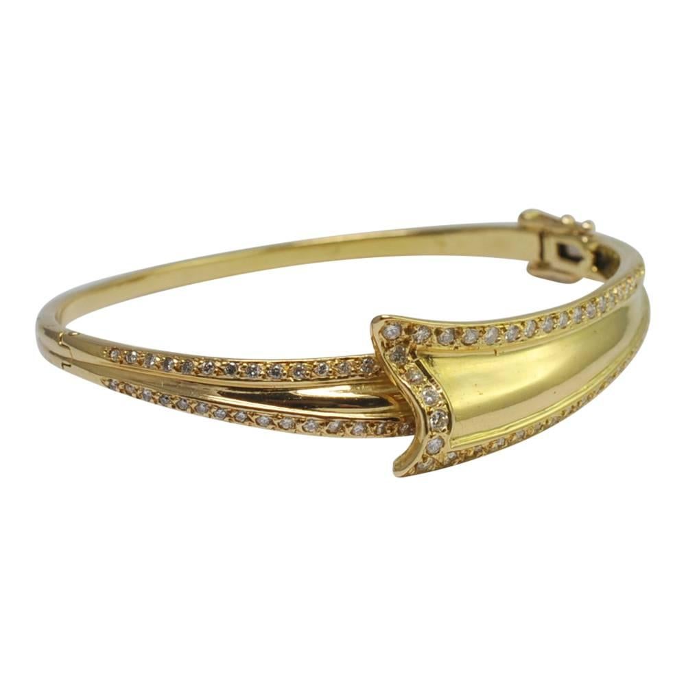 French diamond and 18ct gold ribbon shaped bangle; this pretty vintage bangle is set with 1.50ct of brilliant cut diamonds; it closes with a side hinge and has two figures-of-eight locks for added security. The internal diameter is 5.5cms so it will
