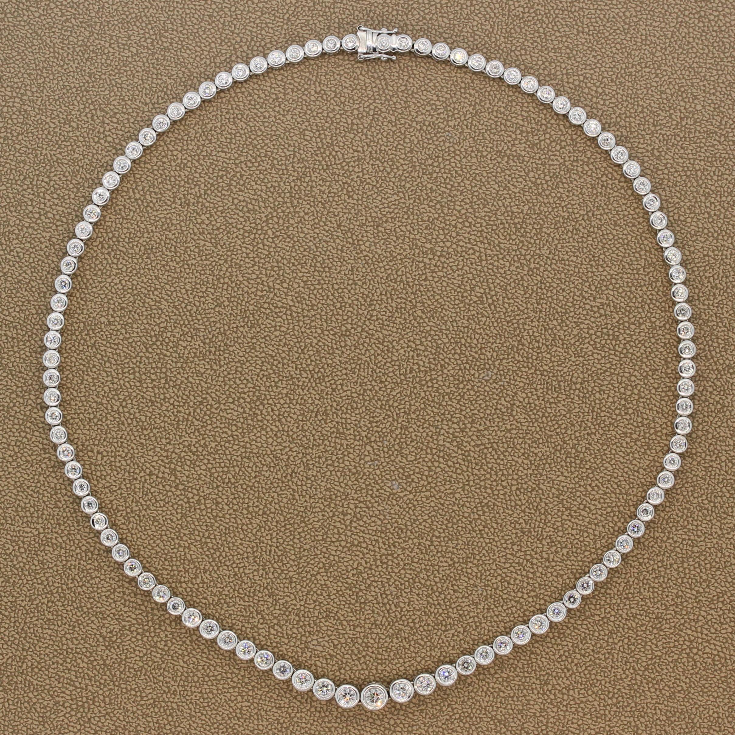 A crisply gleaming necklace featuring 6.88 carats of round cut diamonds. The graduating bezel set colorless VS-SI clarity diamonds are set in 18K white gold. This classic eternity necklace has a box clasp closure with a safety latch on each side. 