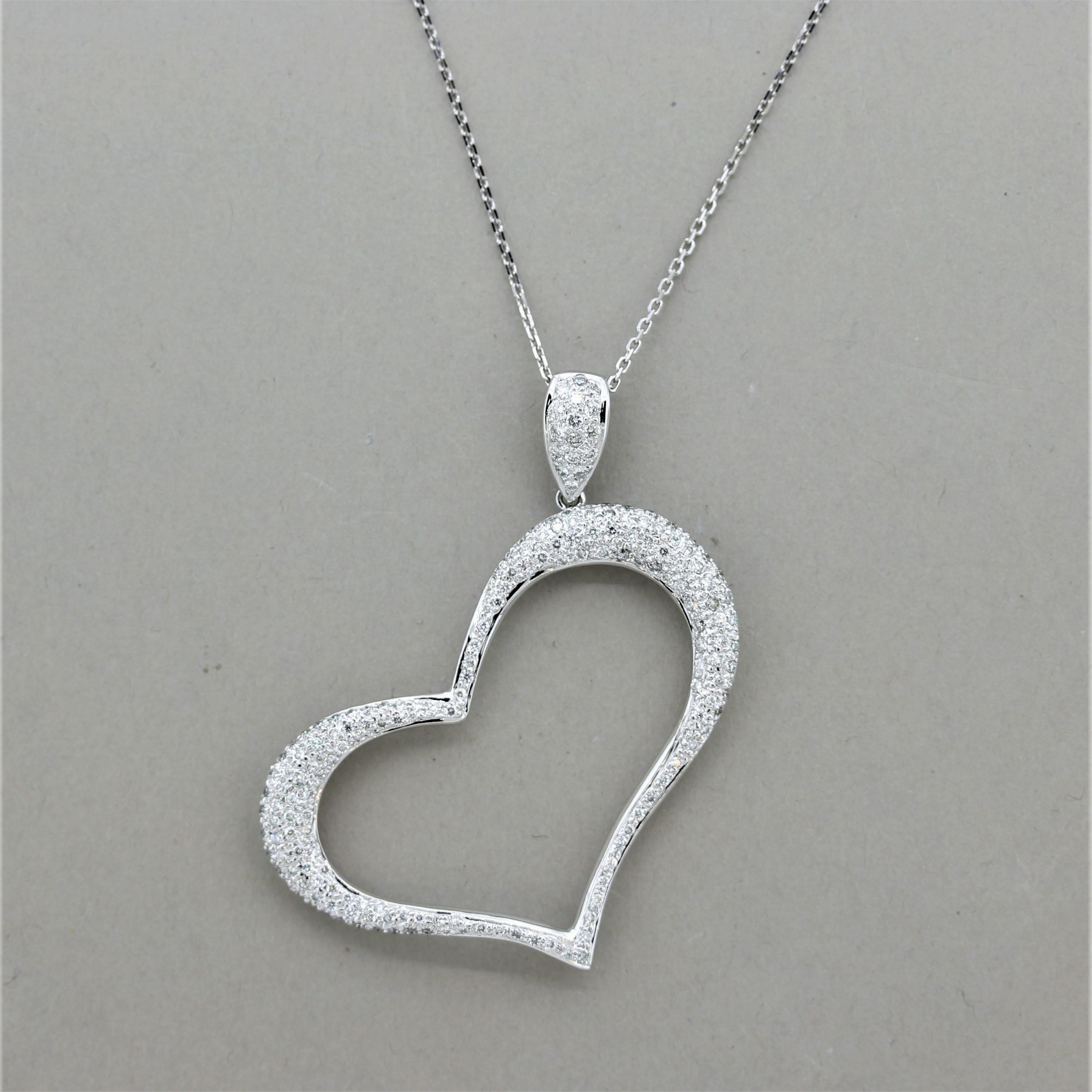 A sweet and larger sized heart pendant which is tilted slightly on its side and dropped from the top bail. It features 1.49 carats of round brilliant-cut diamonds which are set around the heart and bail. Made in 18k white gold and ready to be worn