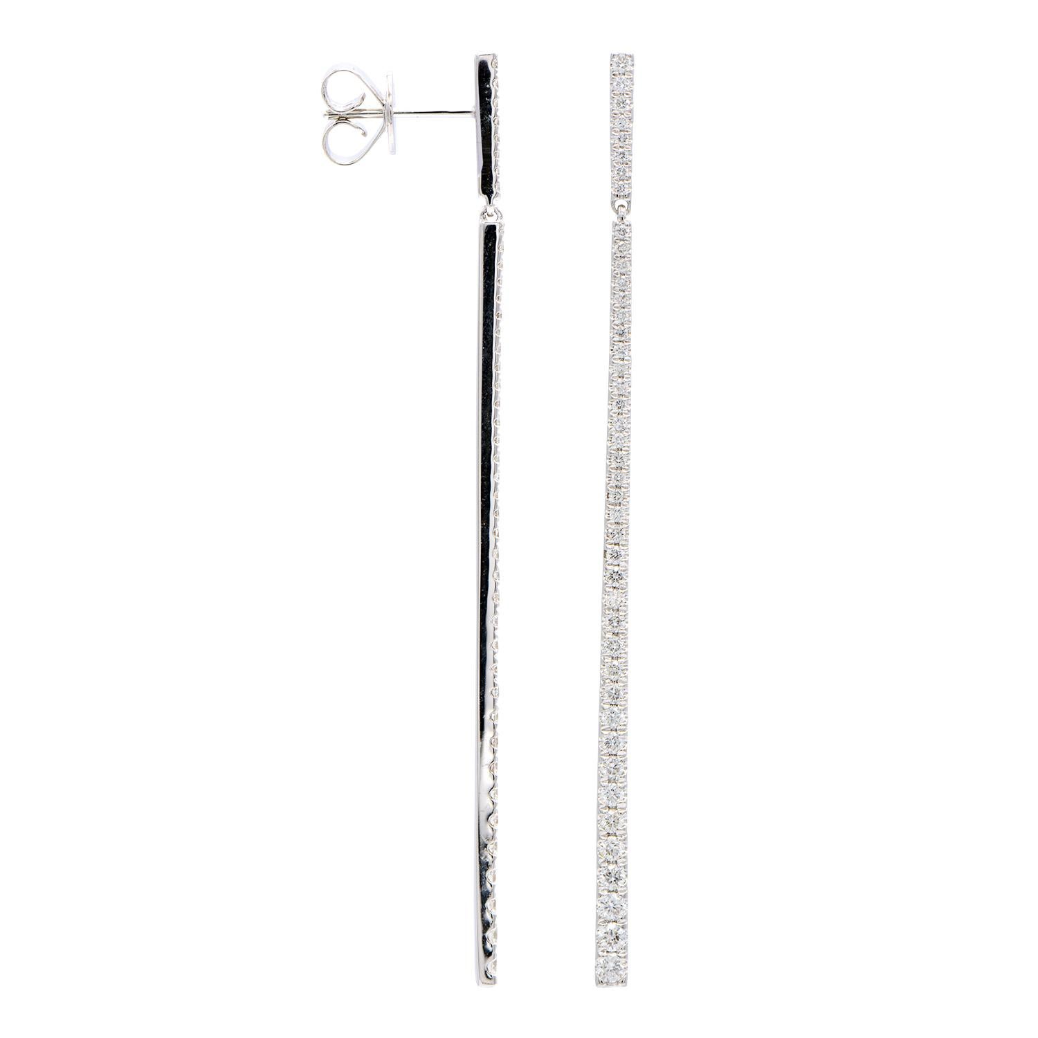 These modern and fun earrings go with everything! These hanging earrings are made from 5.0 grams of 18-karat white gold. Each earring has a secure top piece with a stud back then has a dangling long bottom piece. The diamonds are in a straight line