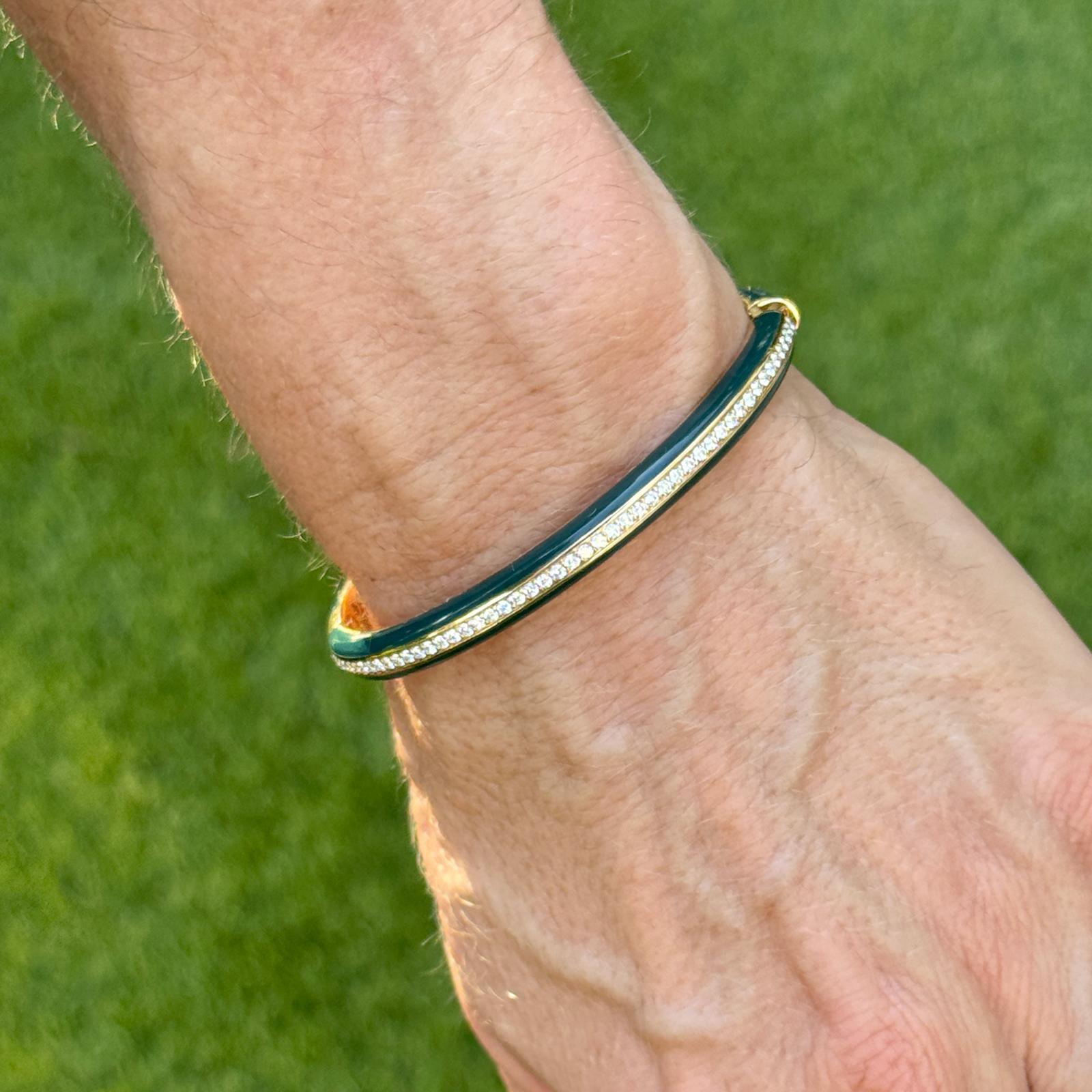 La sophistication moderne rencontre le luxe intemporel dans ce remarquable bracelet à charnière en or jaune 18 carats. Conçu dans une forme ovale élégante pour convenir aux poignets jusqu'à 6,5 pouces, le bracelet présente une rangée centrale de 100