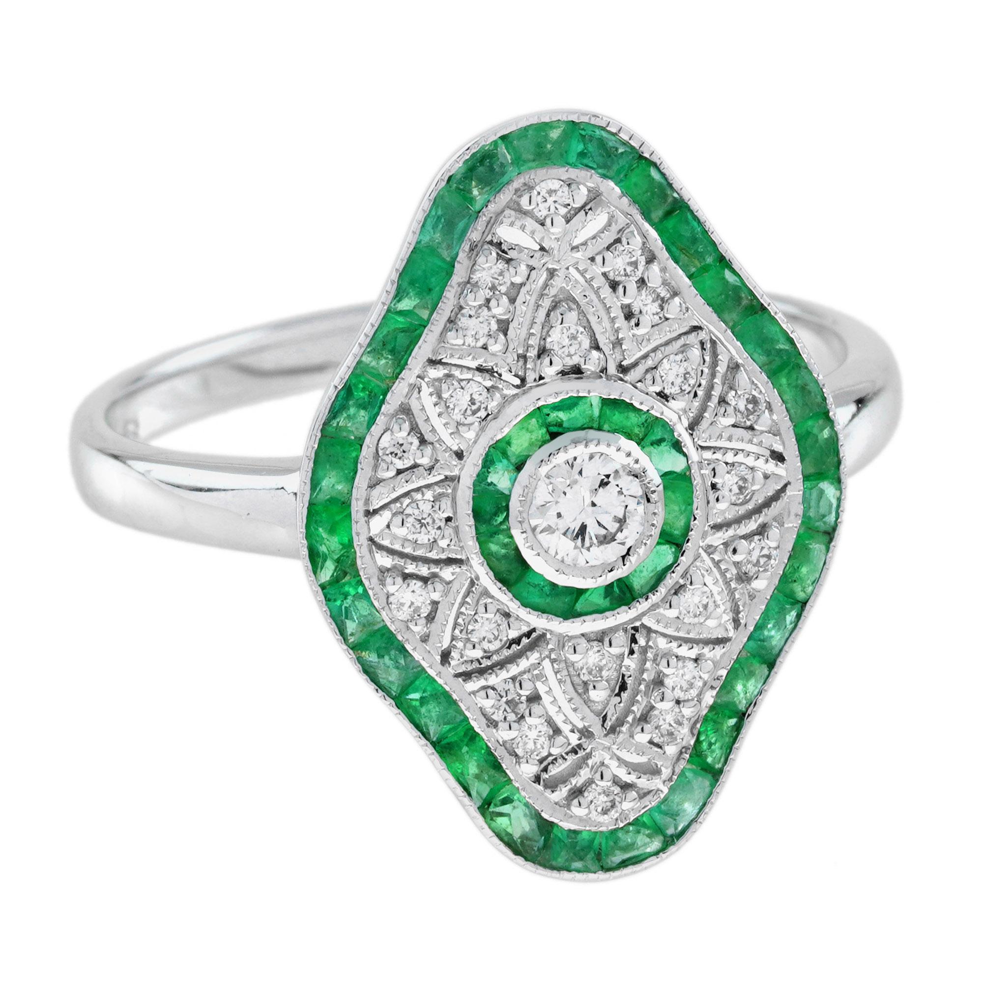 This beautiful ring features an approx. 0.20 carat center diamond and emerald in a gorgeous Art Deco inspired white gold setting. The gemstones are set on an open-work setting. This would make a very special engagement or right hand ring.  
Ring