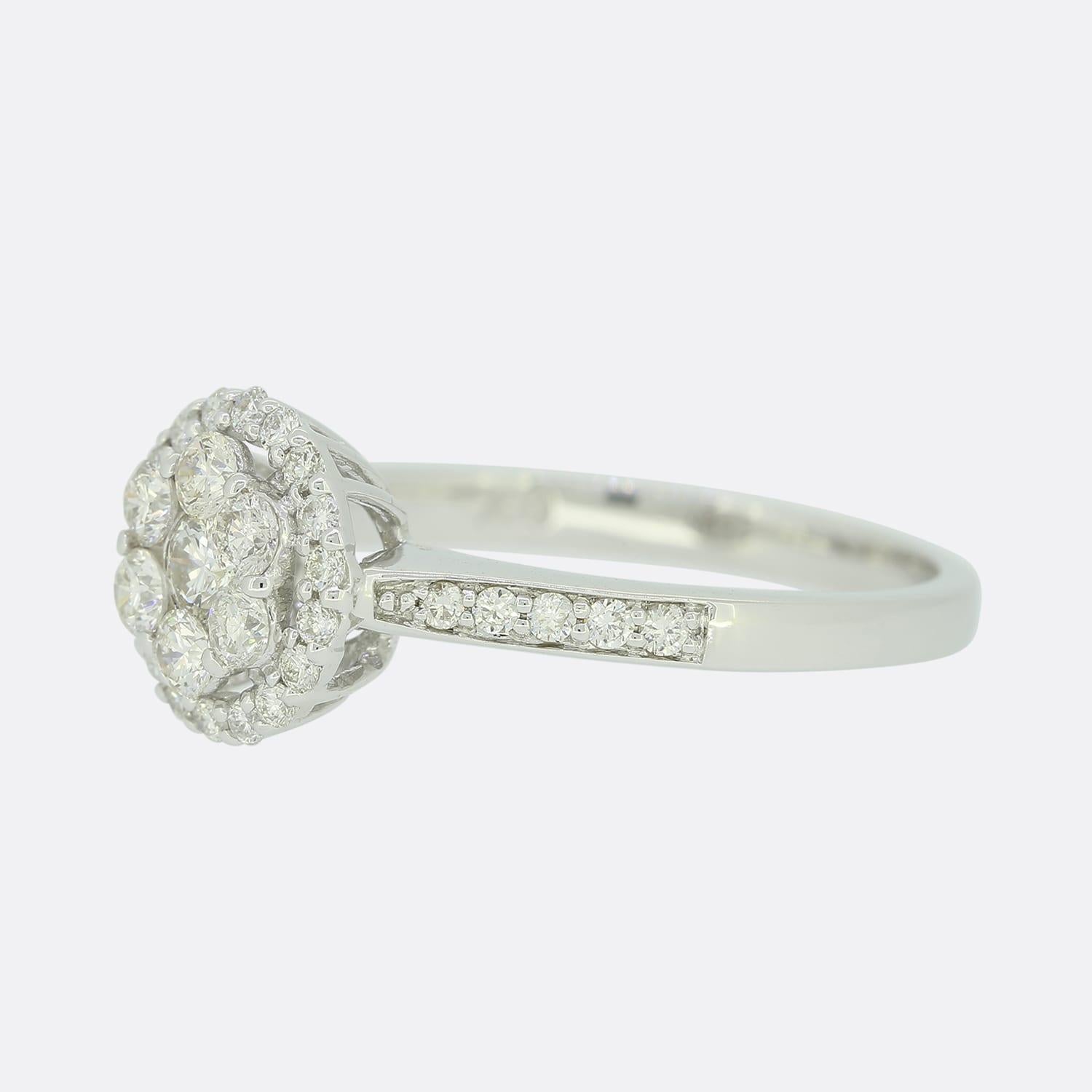 This is an 18ct white gold multi diamond round cluster ring. Featuring a single round diamond surrounded by six round diamonds set on a raised mount with a halo style circle encrusted with eighteen smaller round diamonds. This dazzling ring is