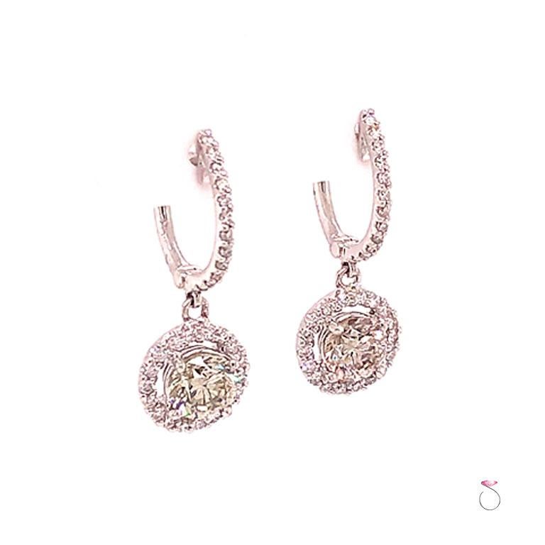 Beautiful Diamond halo drop dangling earrings in 18k white gold. These gorgeous earrings feature two round brilliant cut diamonds at the center, each measuring approximately 6.00 mm x 6.00 mm x 4.15 mm with the carat weight of 0.90 and 0.92 ct.